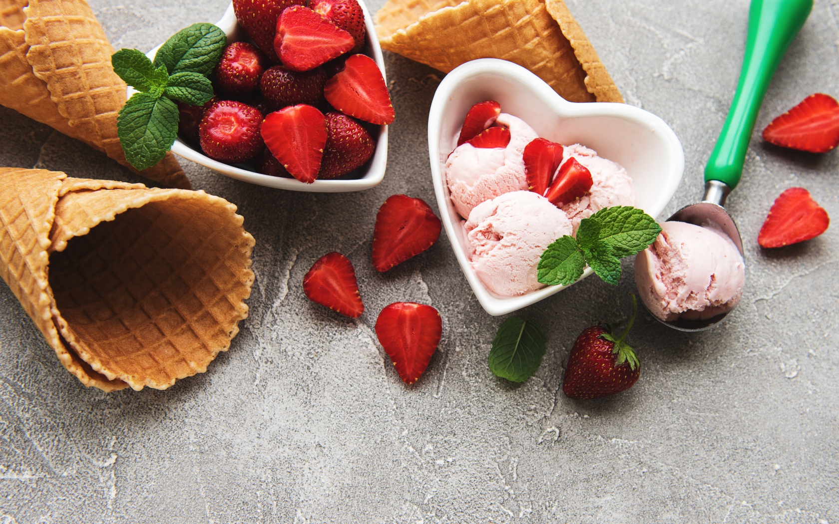 Вафельные рожки на столе с фруктовым мороженым и ягодами клубники 