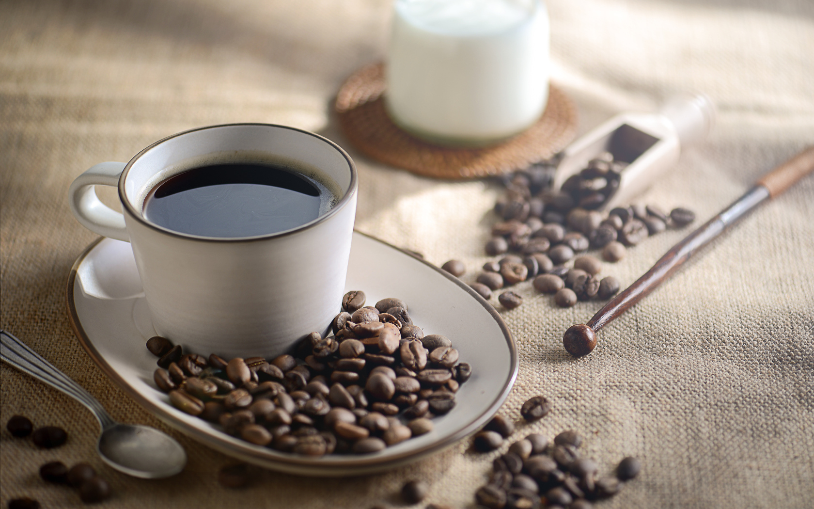 Чашка крепкого кофе на столе с зернами