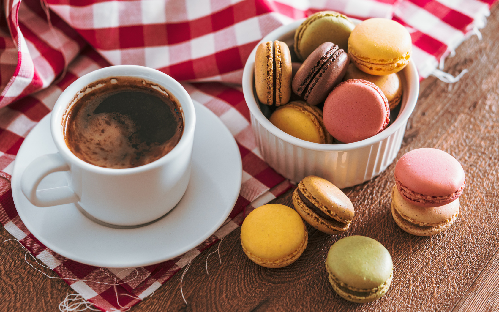 Чашка кофе на столе с десертом макарун 