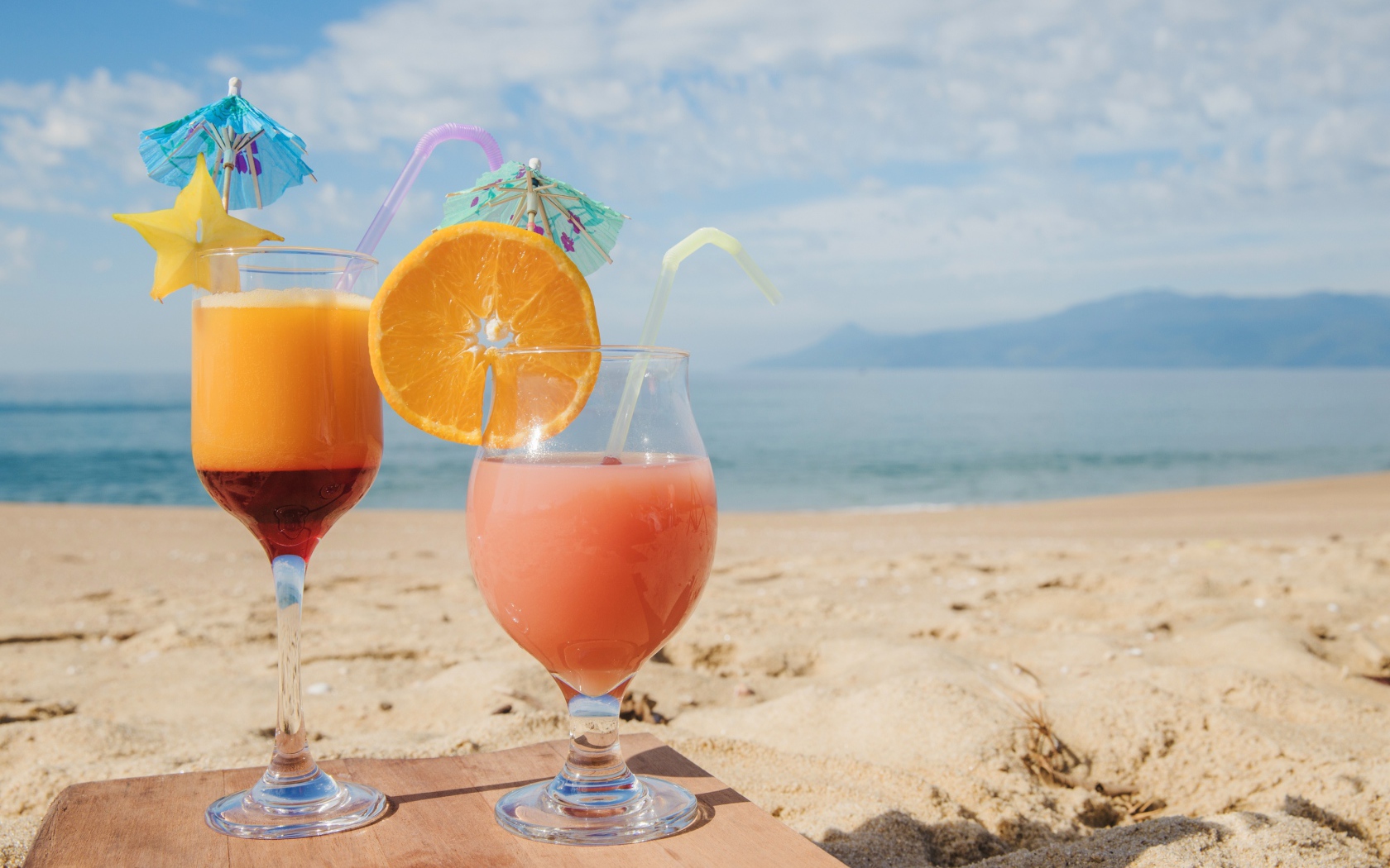 Два тропических коктейля на пляже в лучах солнца