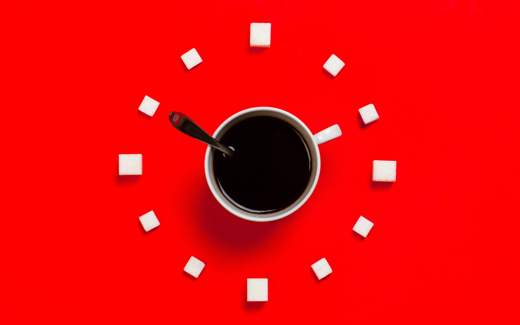 Белая чашка кофе на красном фоне с кубиками сахара 