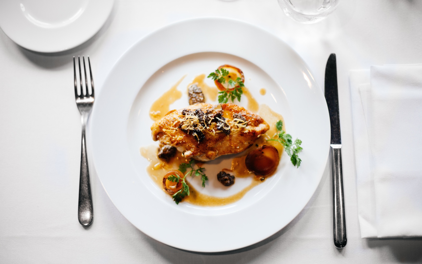 Кусок жареного мяса на большой белой тарелке 