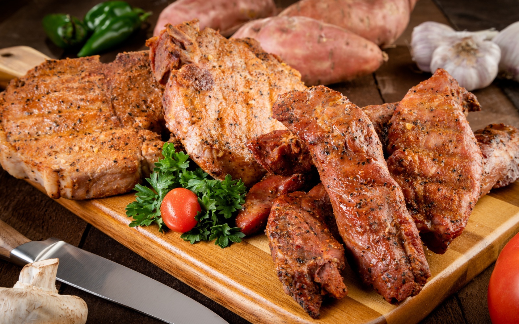 Аппетитное запеченное мясо на столе с чесноком и картофелем