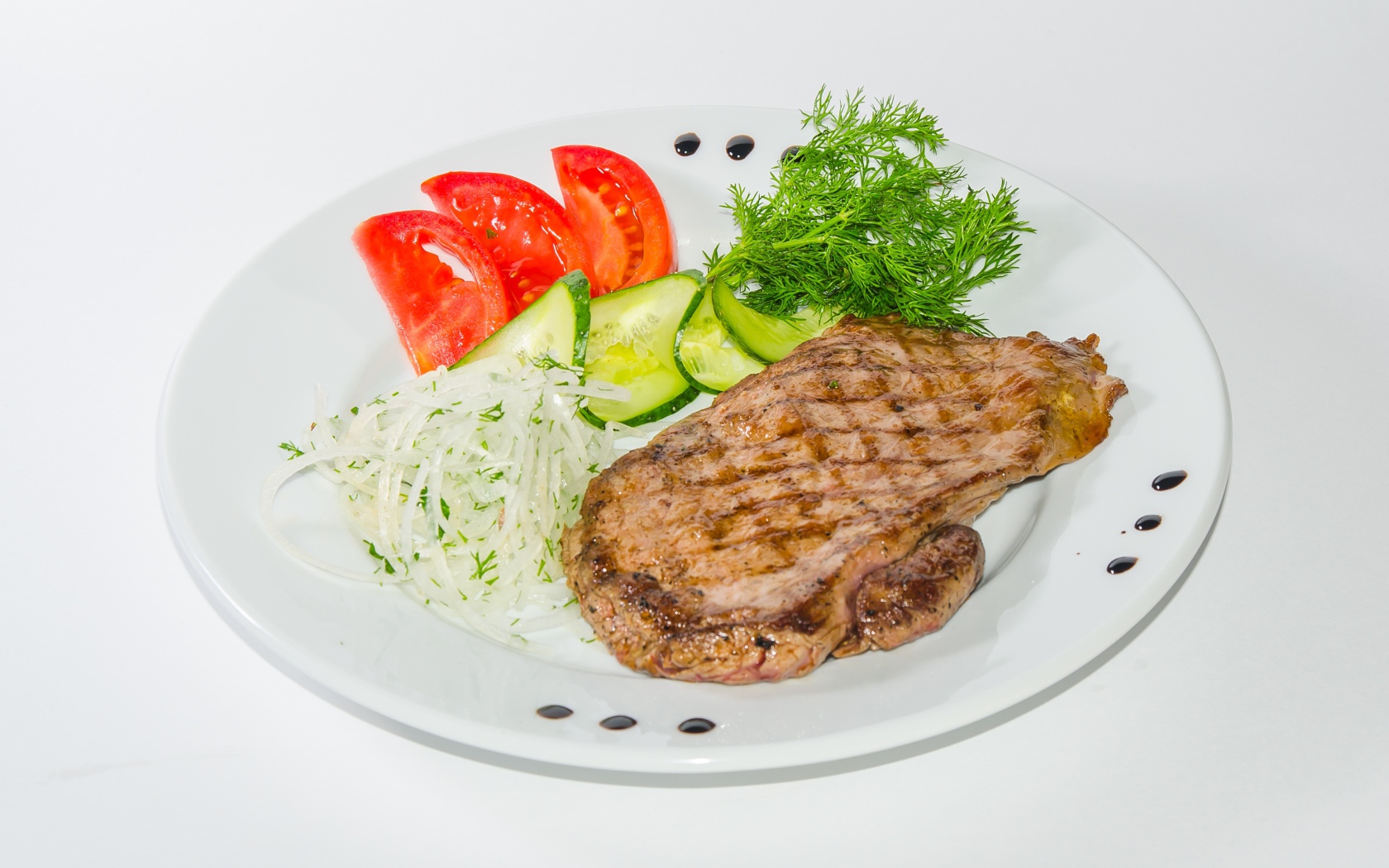 Кусок курицы с овощами на белой тарелке 