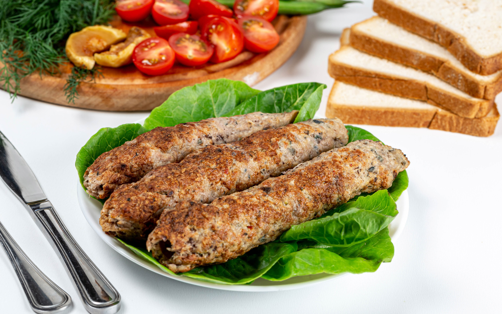 Мясное блюдо кебаб на столе с зелеными листьями 