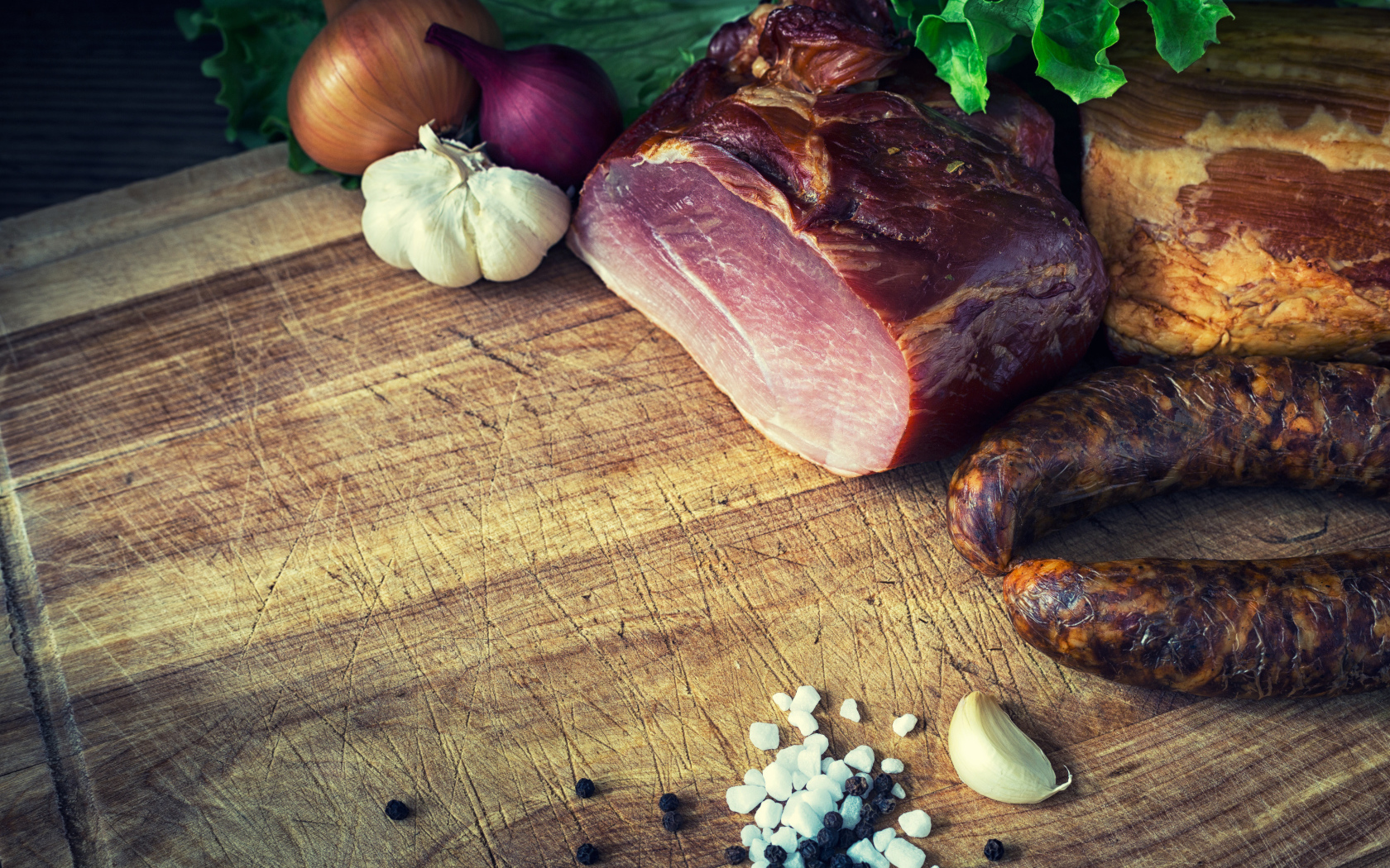 Мясные продукты на столе со специями, луком и чесноком 