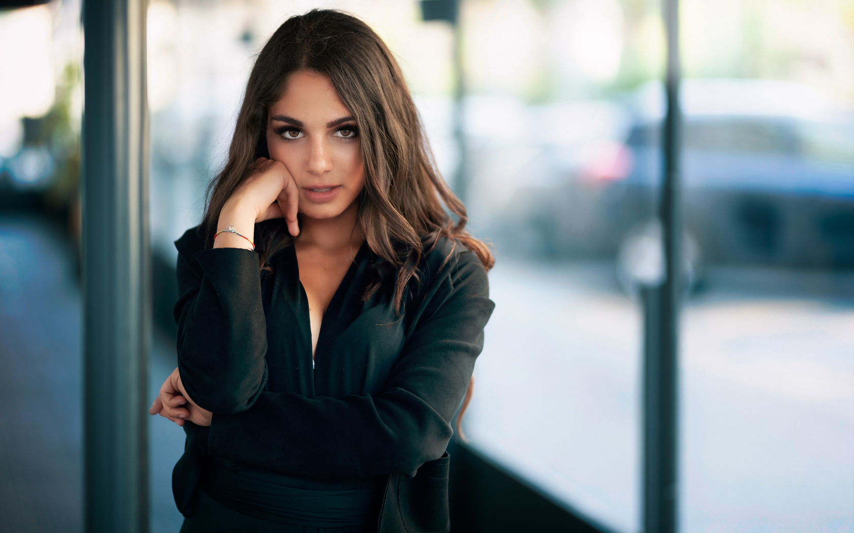 Милая девушка в черном наряде стоит на остановке