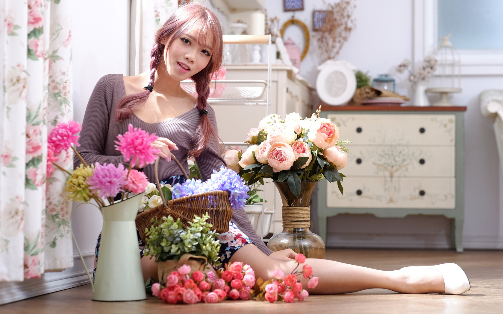 Девушка азиатка сидит с цветами на полу у окна