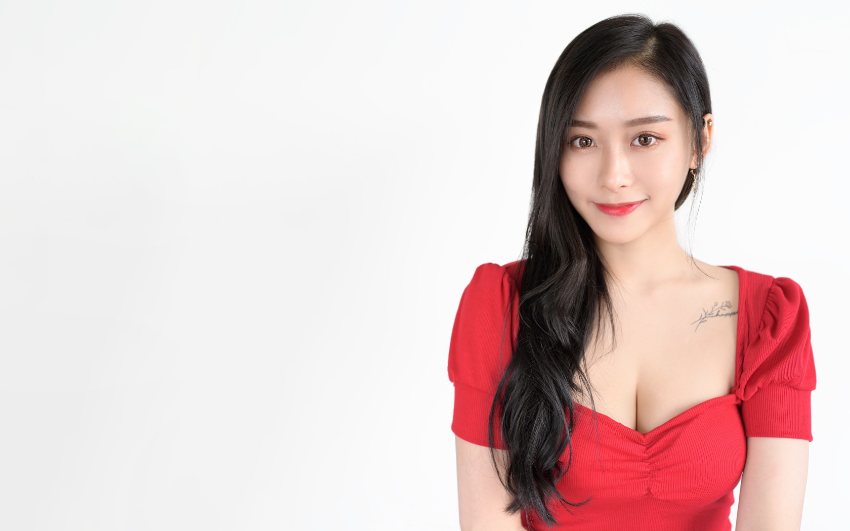 Красивая девушка азиатка в красном платье на белом фоне