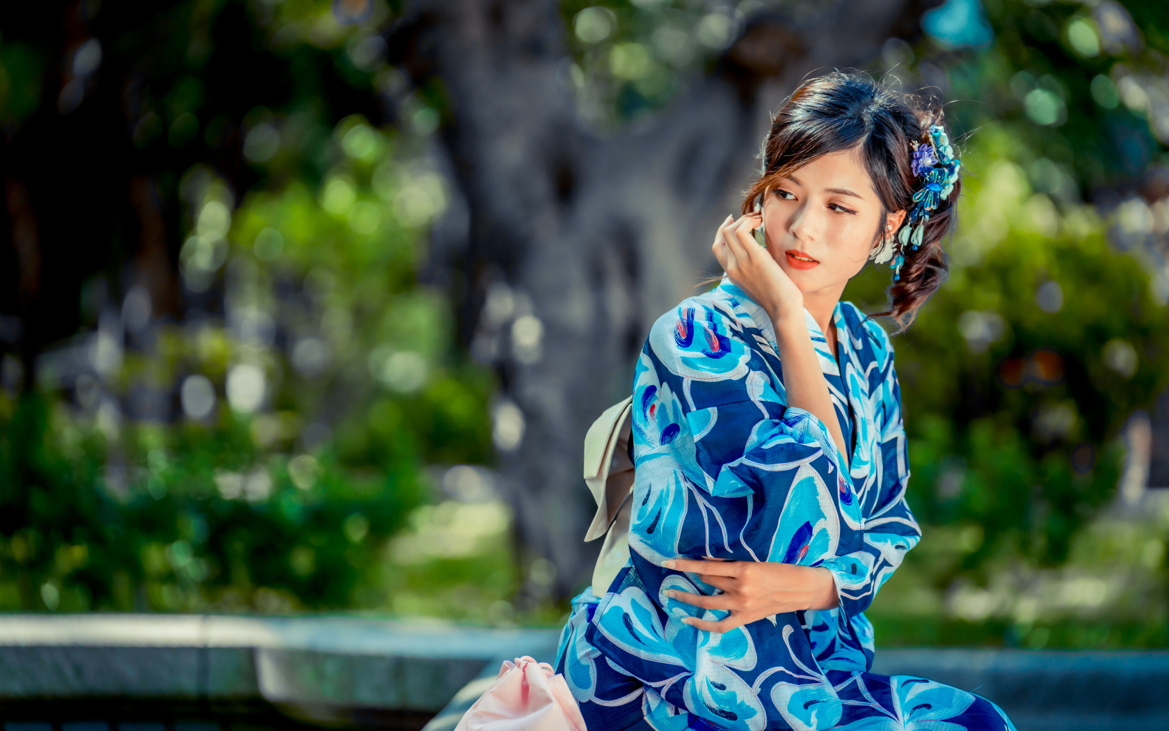 Красивая азиатка в разноцветном кимоно в парке