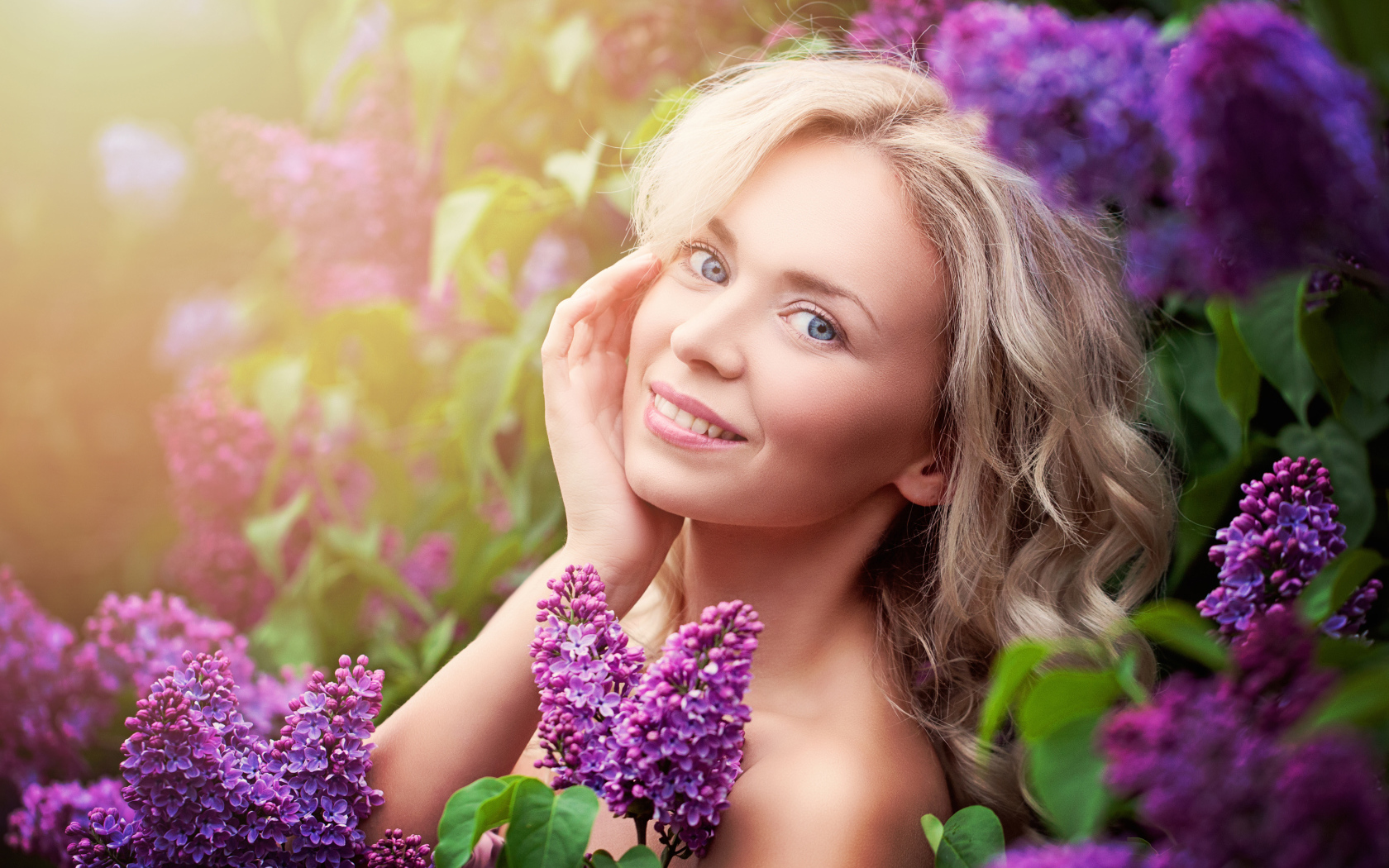 Красивая голубоглазая девушка блондинка в цветах сирени