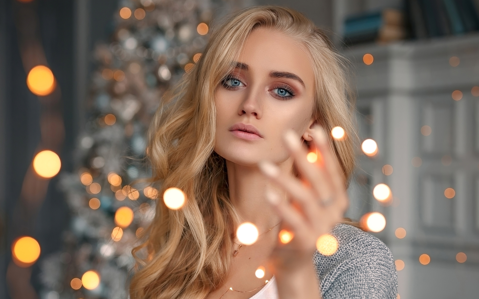 Красивая голубоглазая блондинка с гирляндой в руке