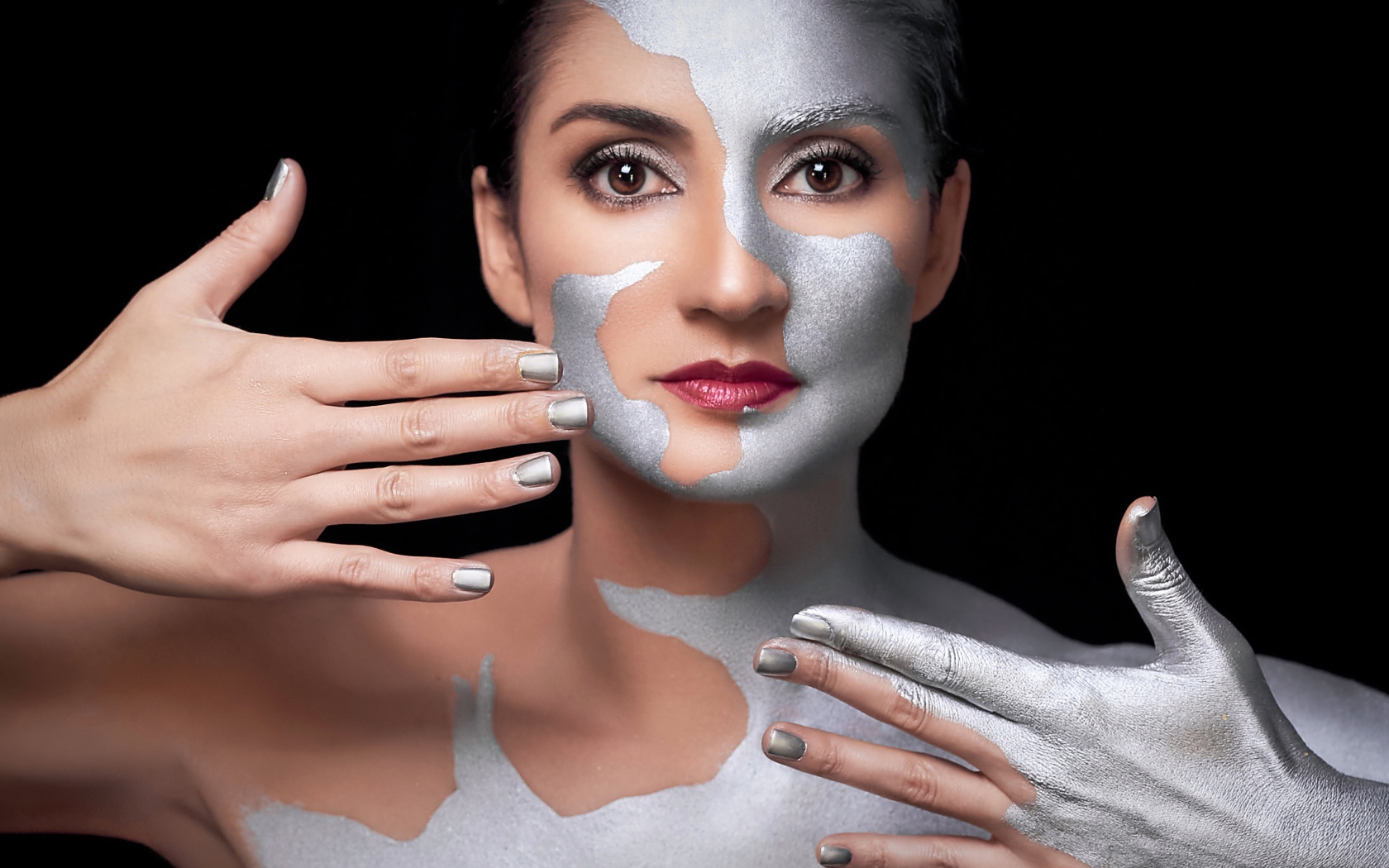 Красивая кареглазая женщина с серебристой краской на теле 