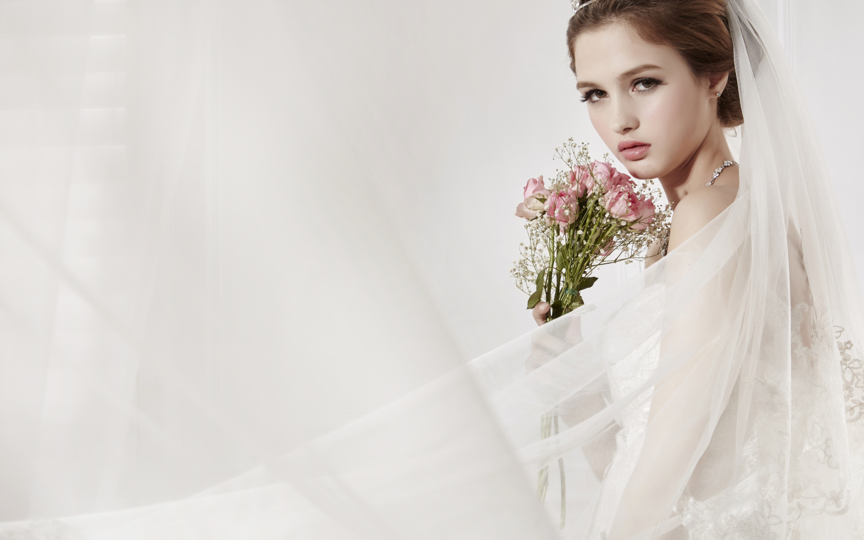 Красивая девушка невеста в свадебном платье с букетом роз 