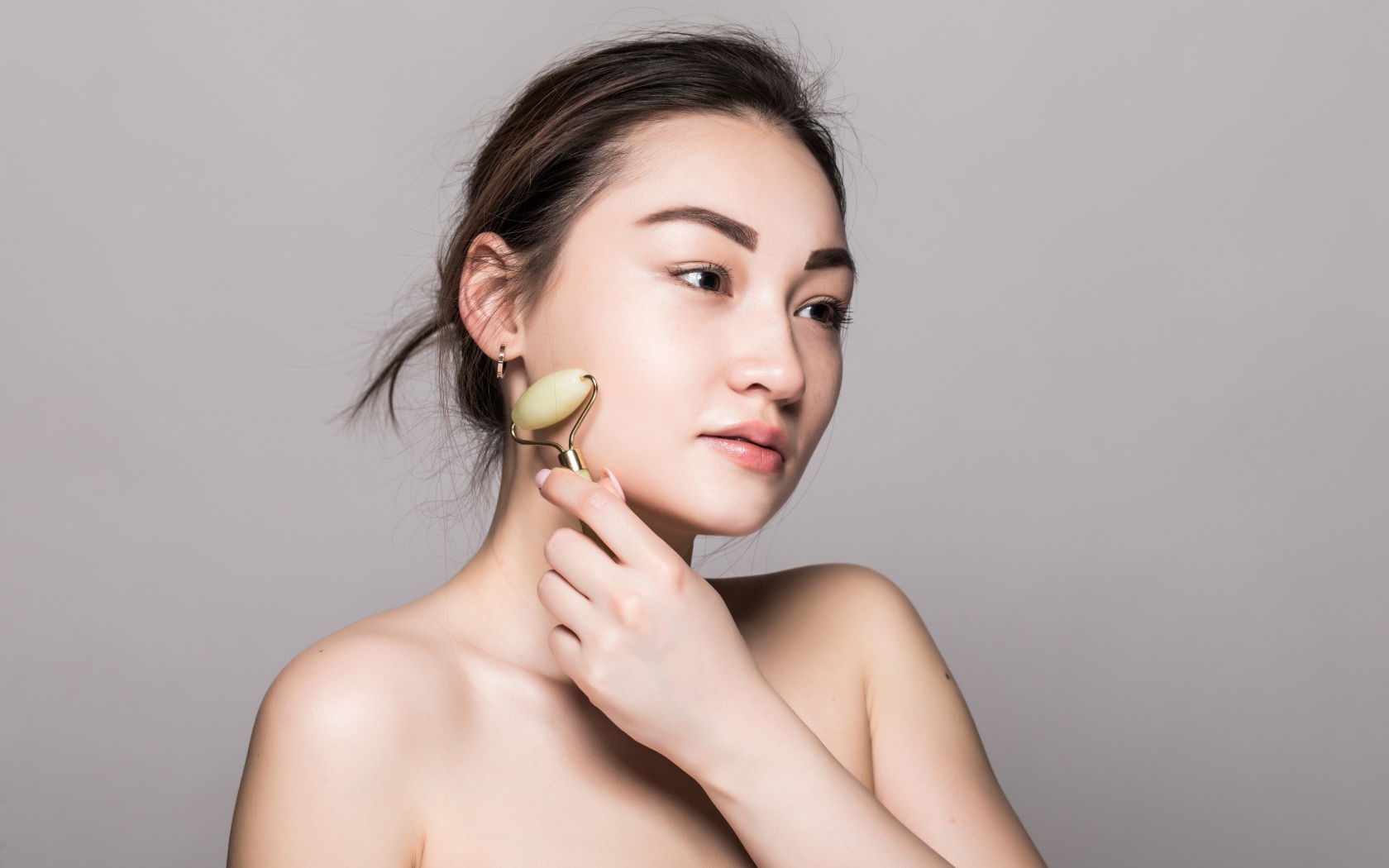 Красивая девушка разглаживает кожу лица