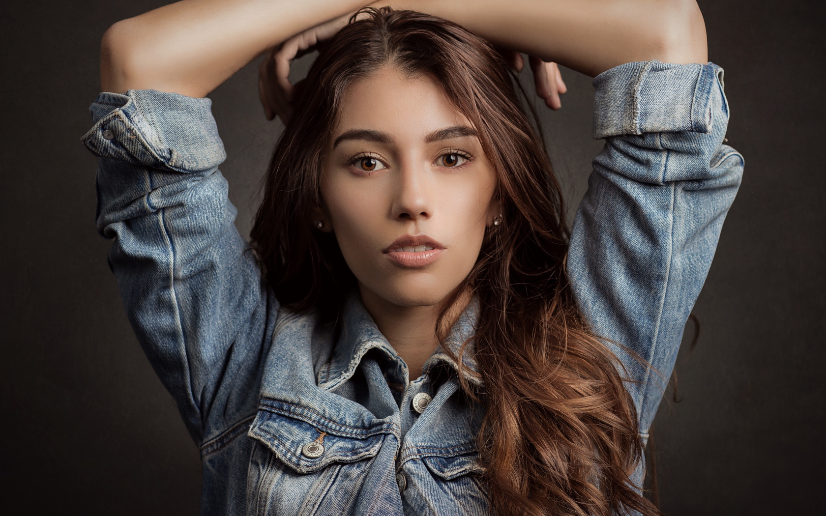 Красивая длинноволосая шатенка в джинсовой куртке 