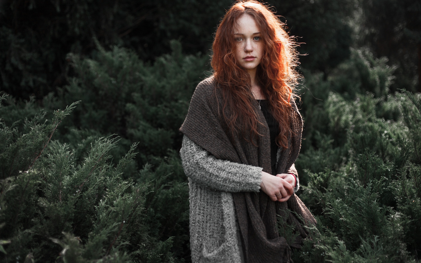 Красивая рыжеволосая девушка в серой кофте 