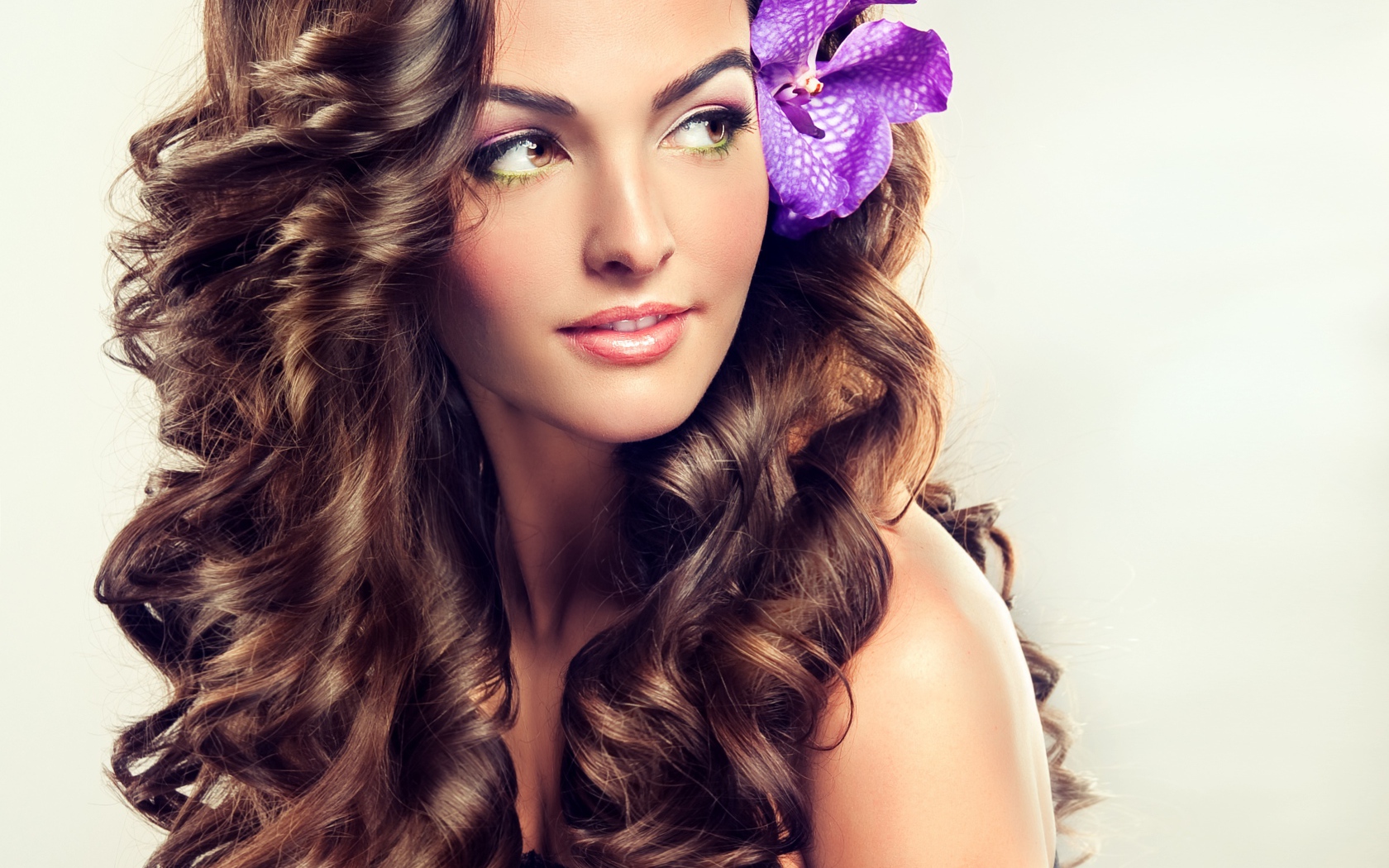 Цветок в красивых длинных волосах молодой девушки