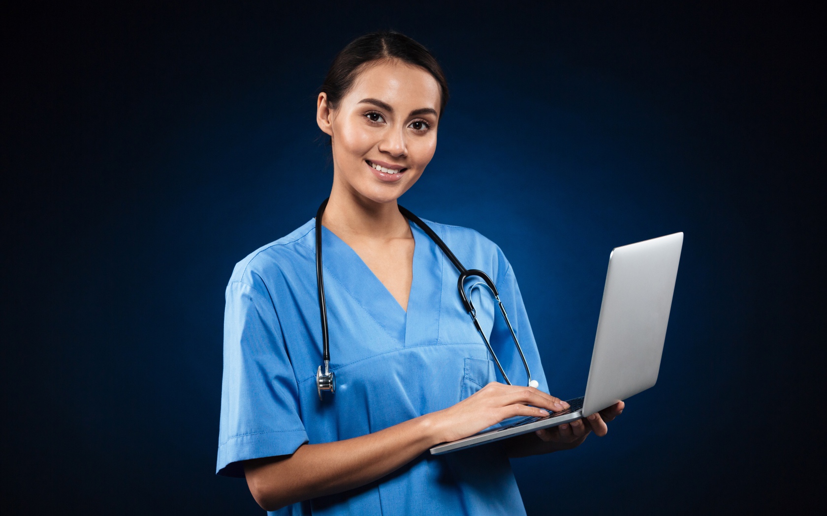 Девушка врач с ноутбуком на синем фоне 