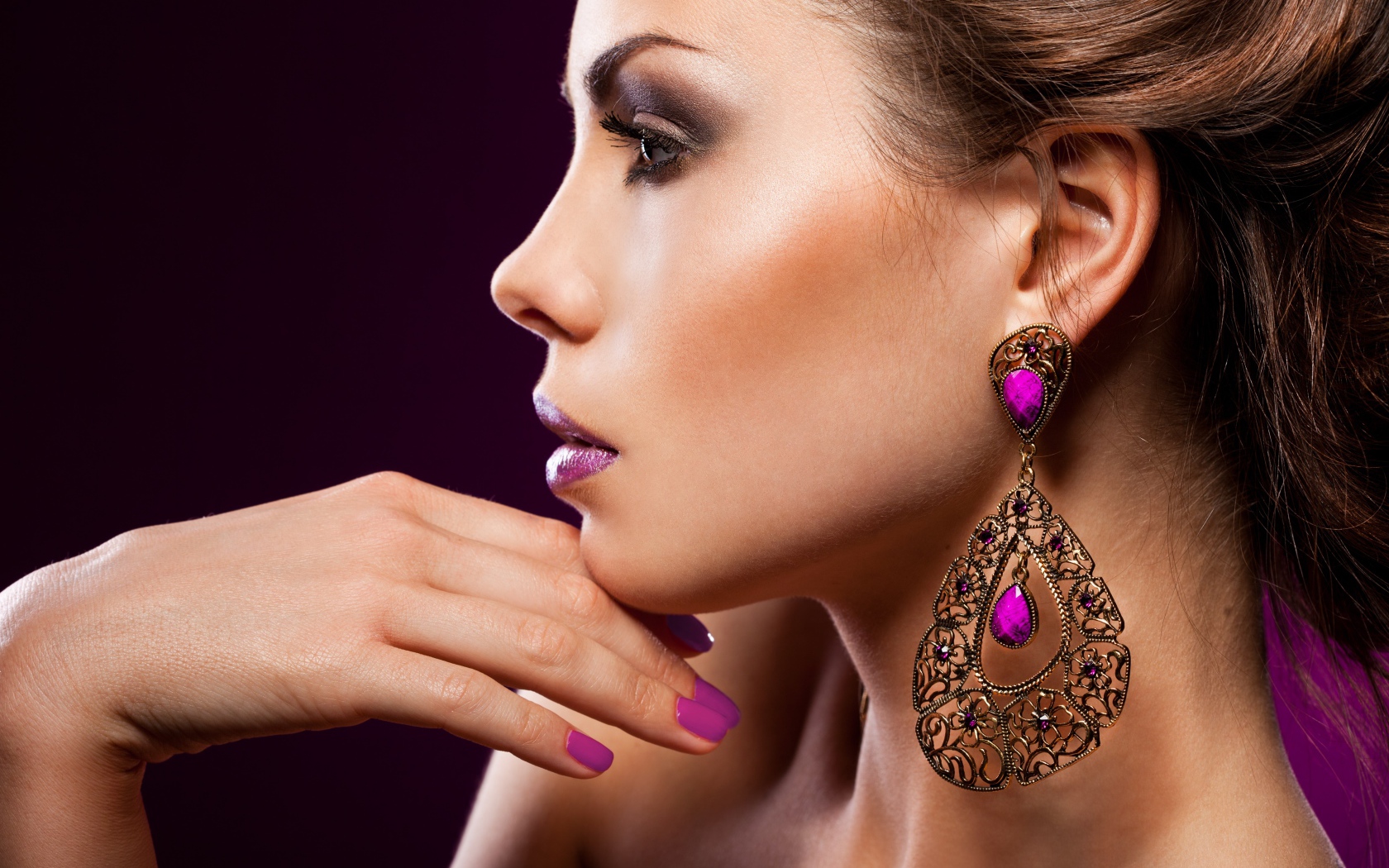 Лицо девушки с красивым макияжем и дорогими серьгами