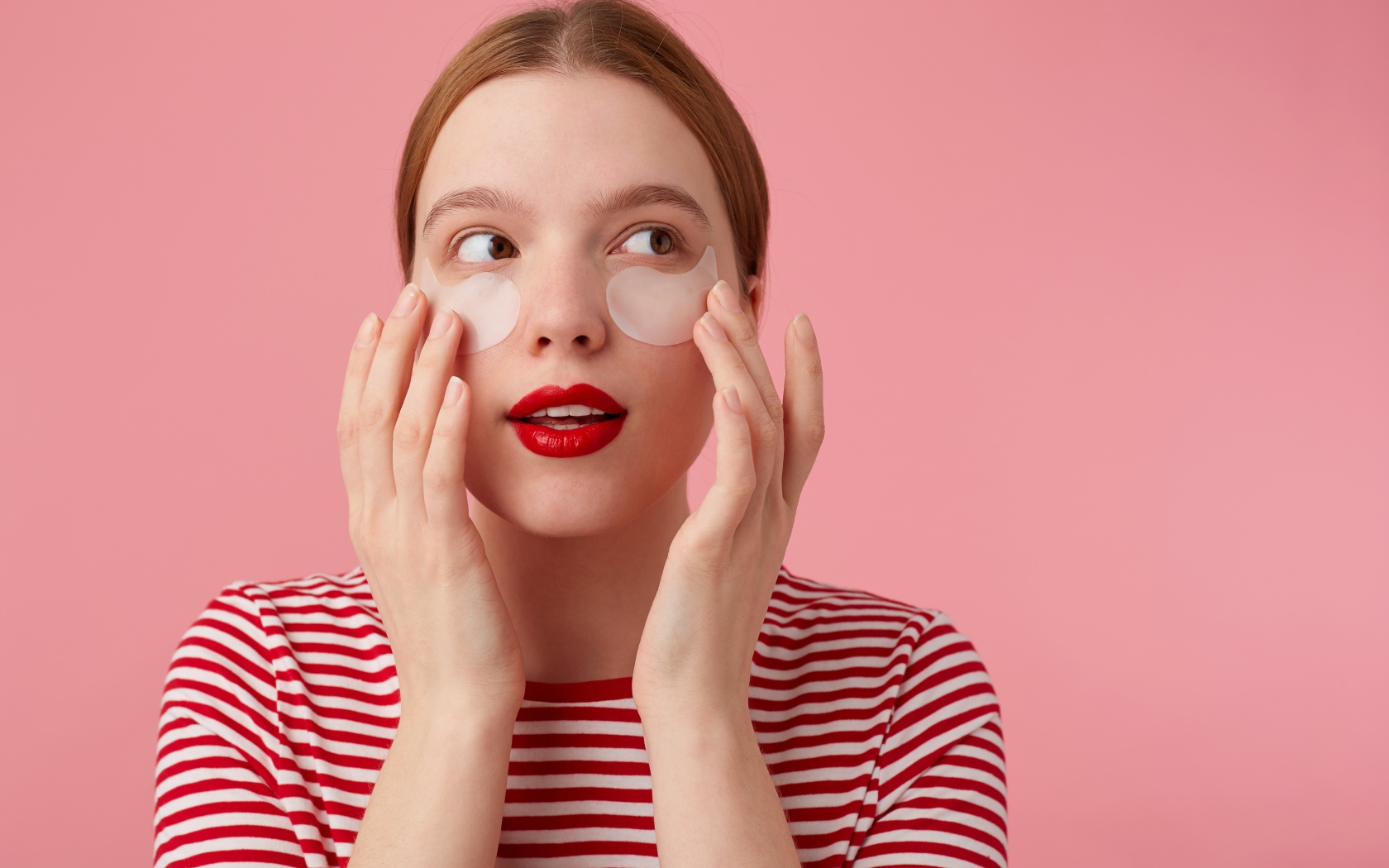 Девушка приклеивает патчи для глаз на лицо 