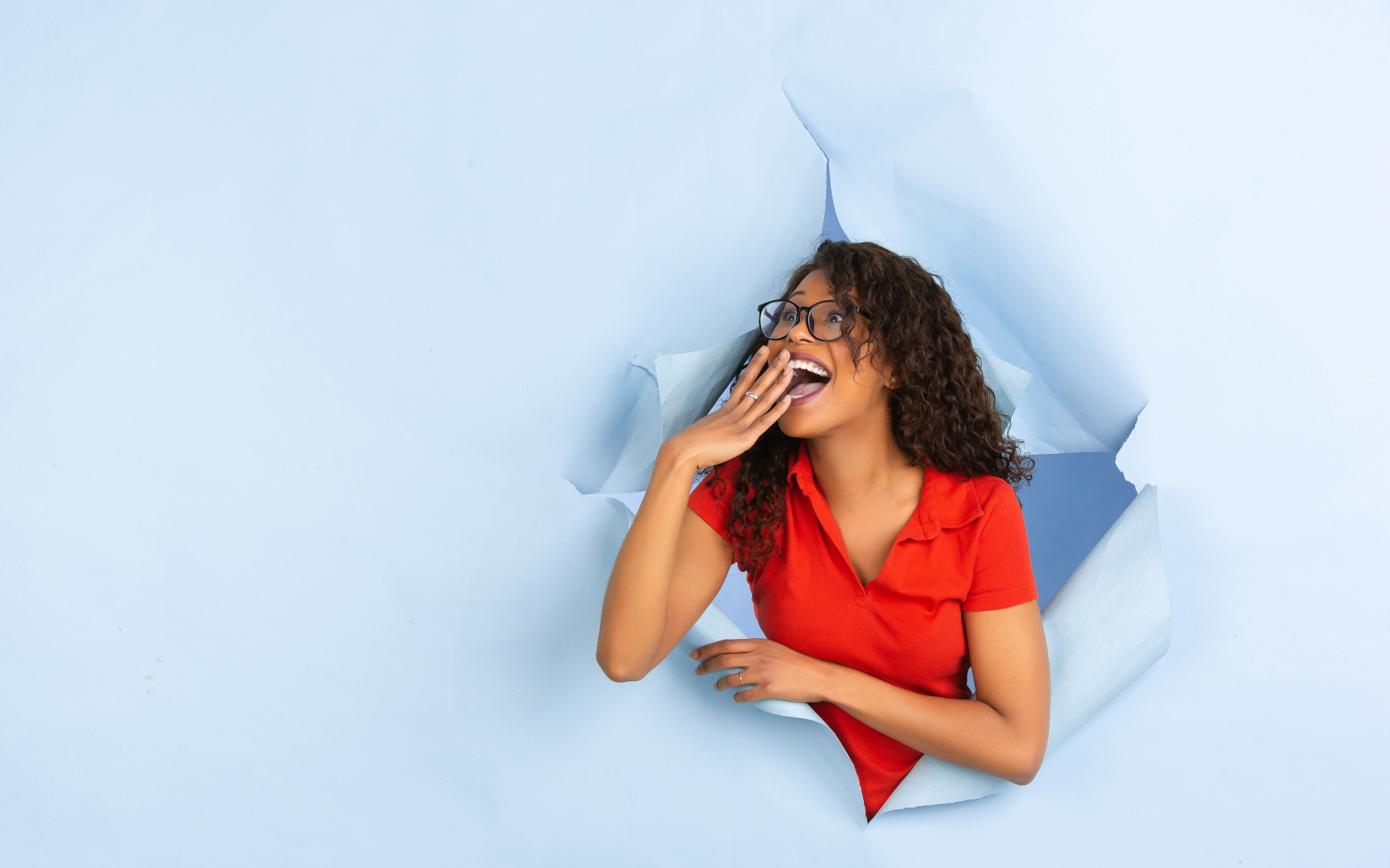 Радостная девушка прорвала дыру в стене