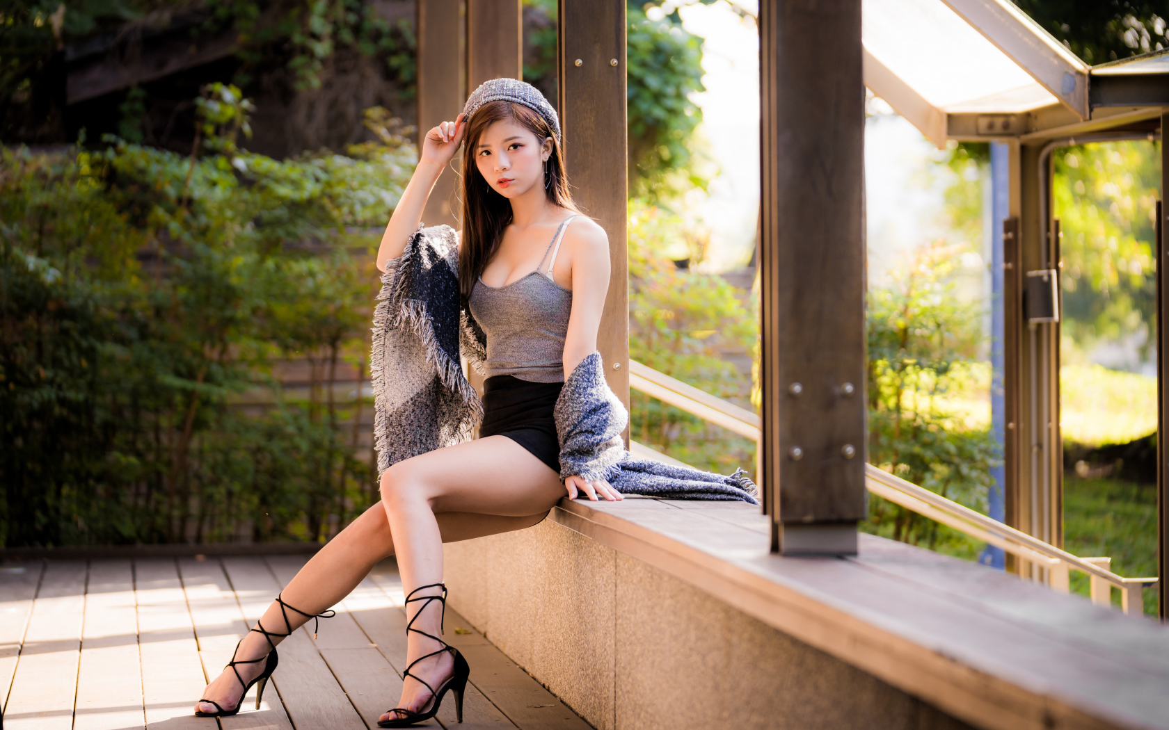Длинноногая азиатка сидит на окне 
