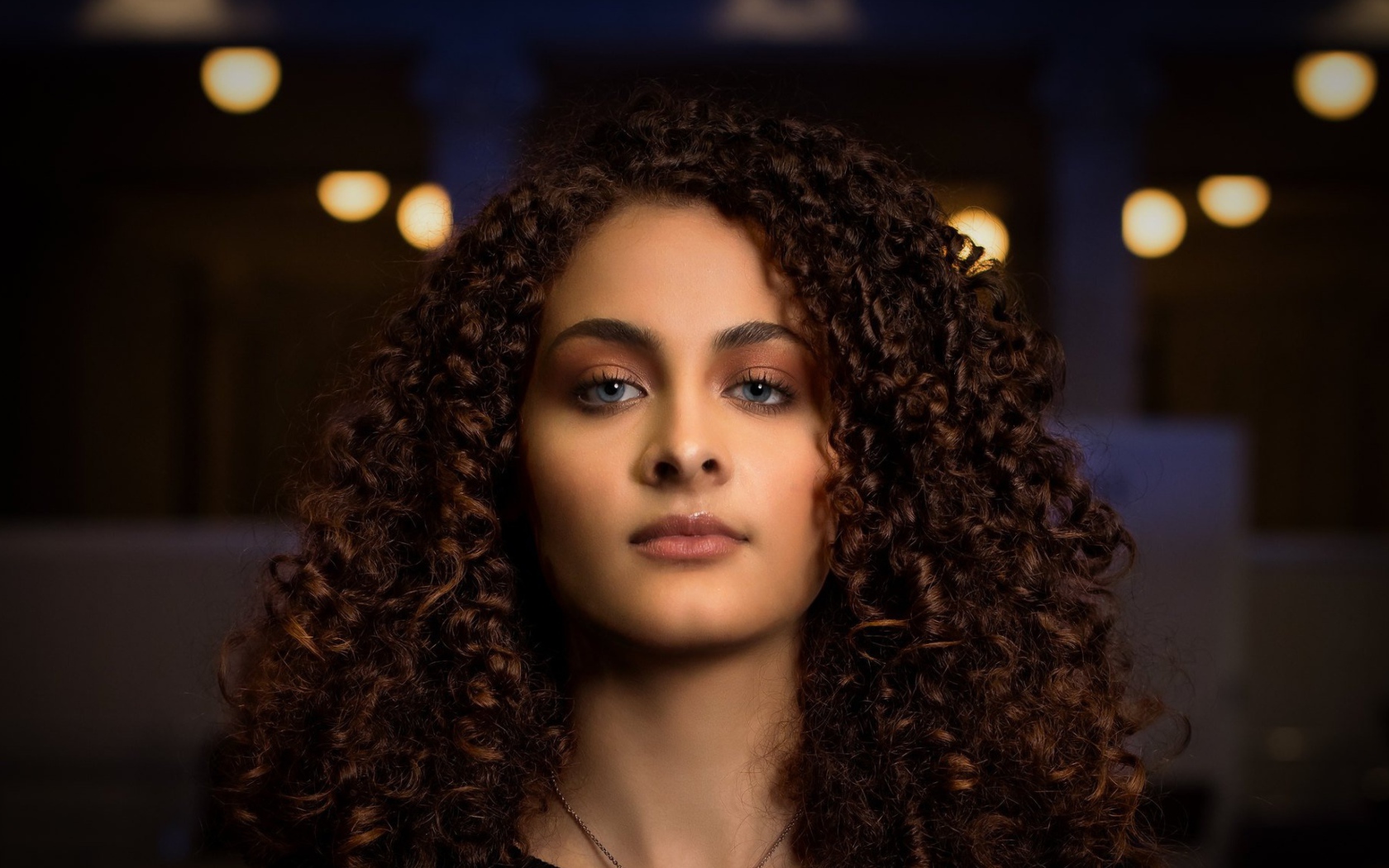 Длинные кудрявые волосы у красивой голубоглазой девушки