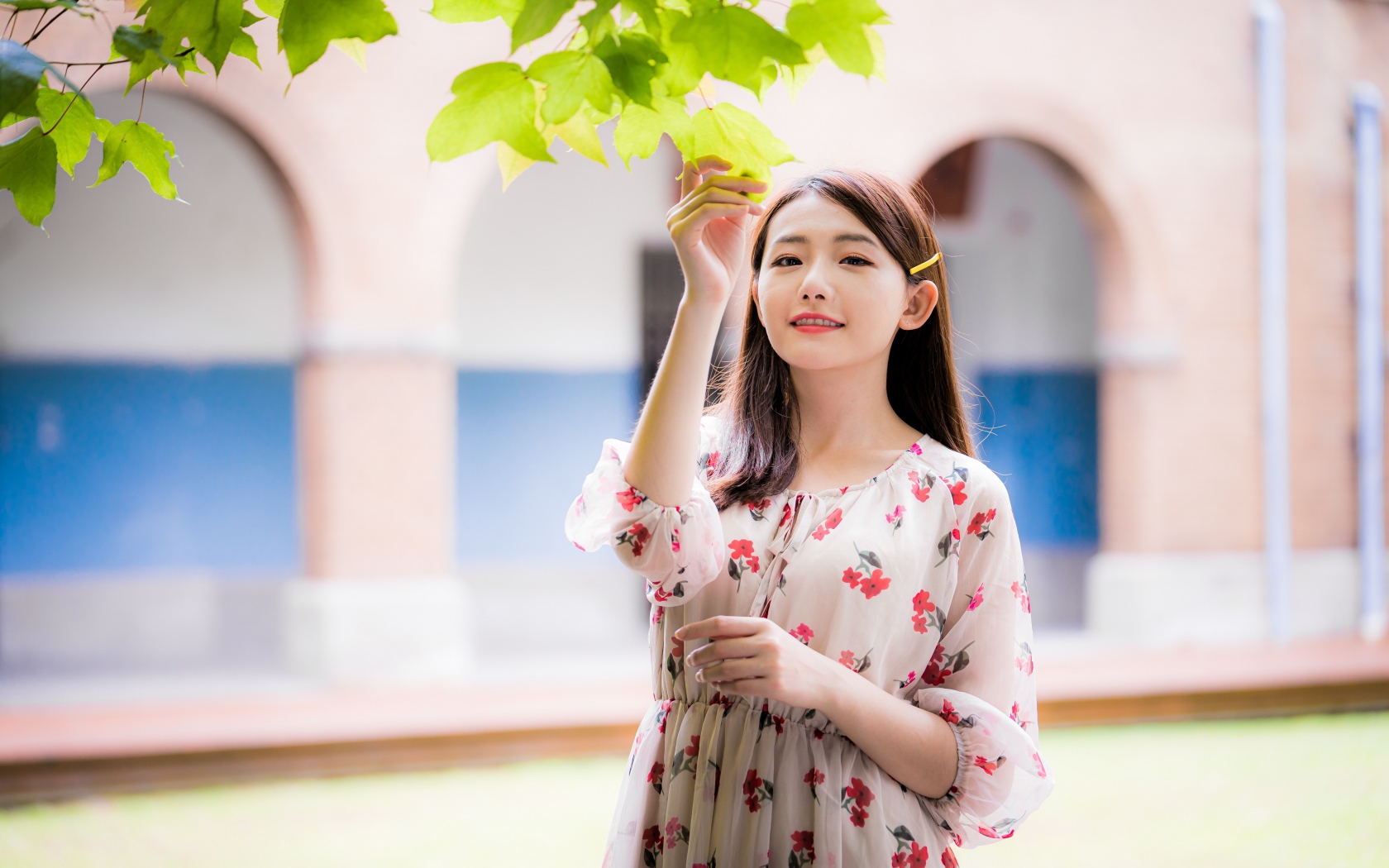 Улыбающаяся девушка в платье у дерева 