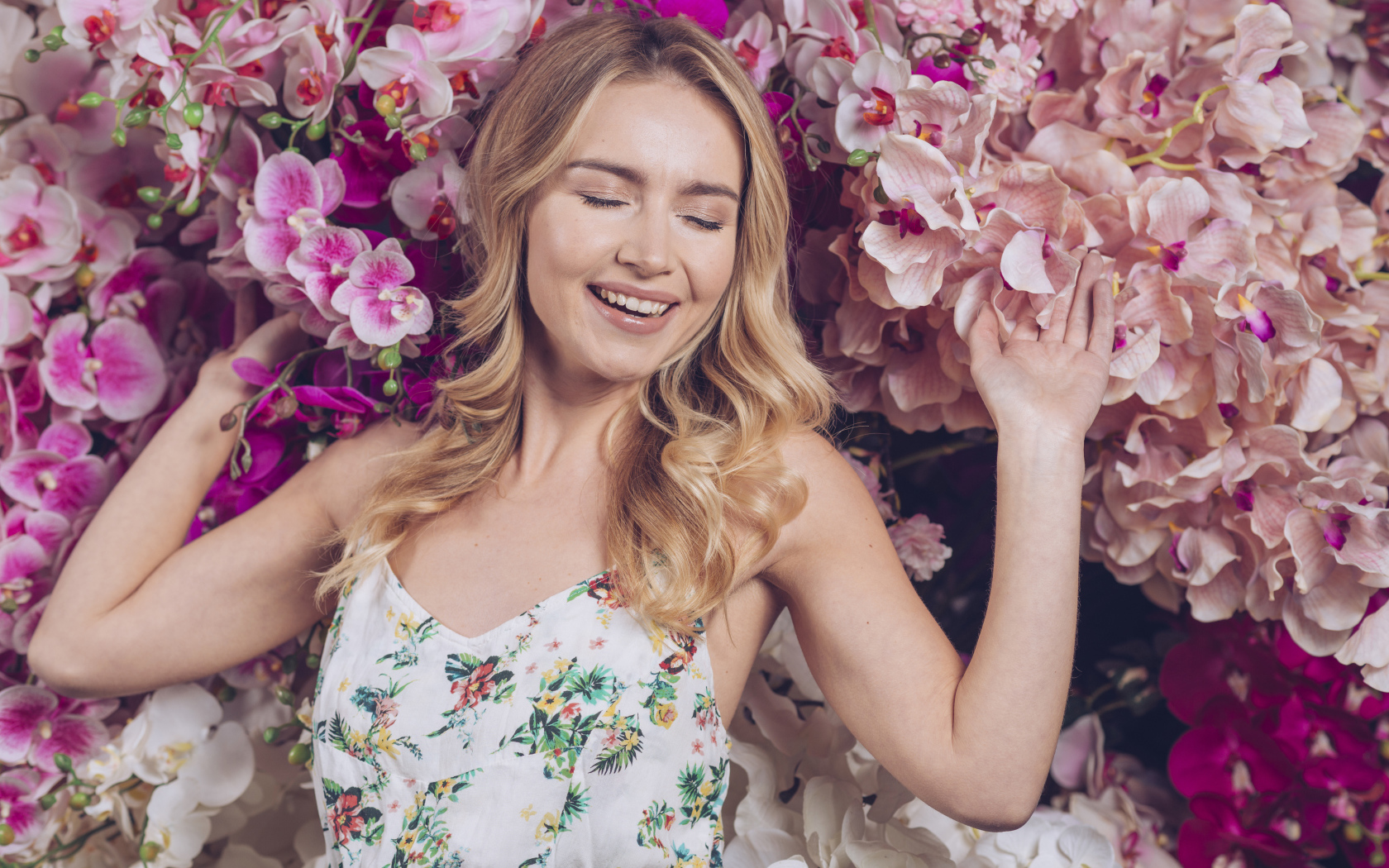 Улыбающаяся счастливая девушка у цветов орхидеи