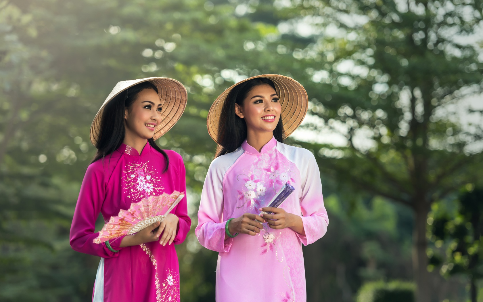Две девушки азиатки в платьях с веером в руках