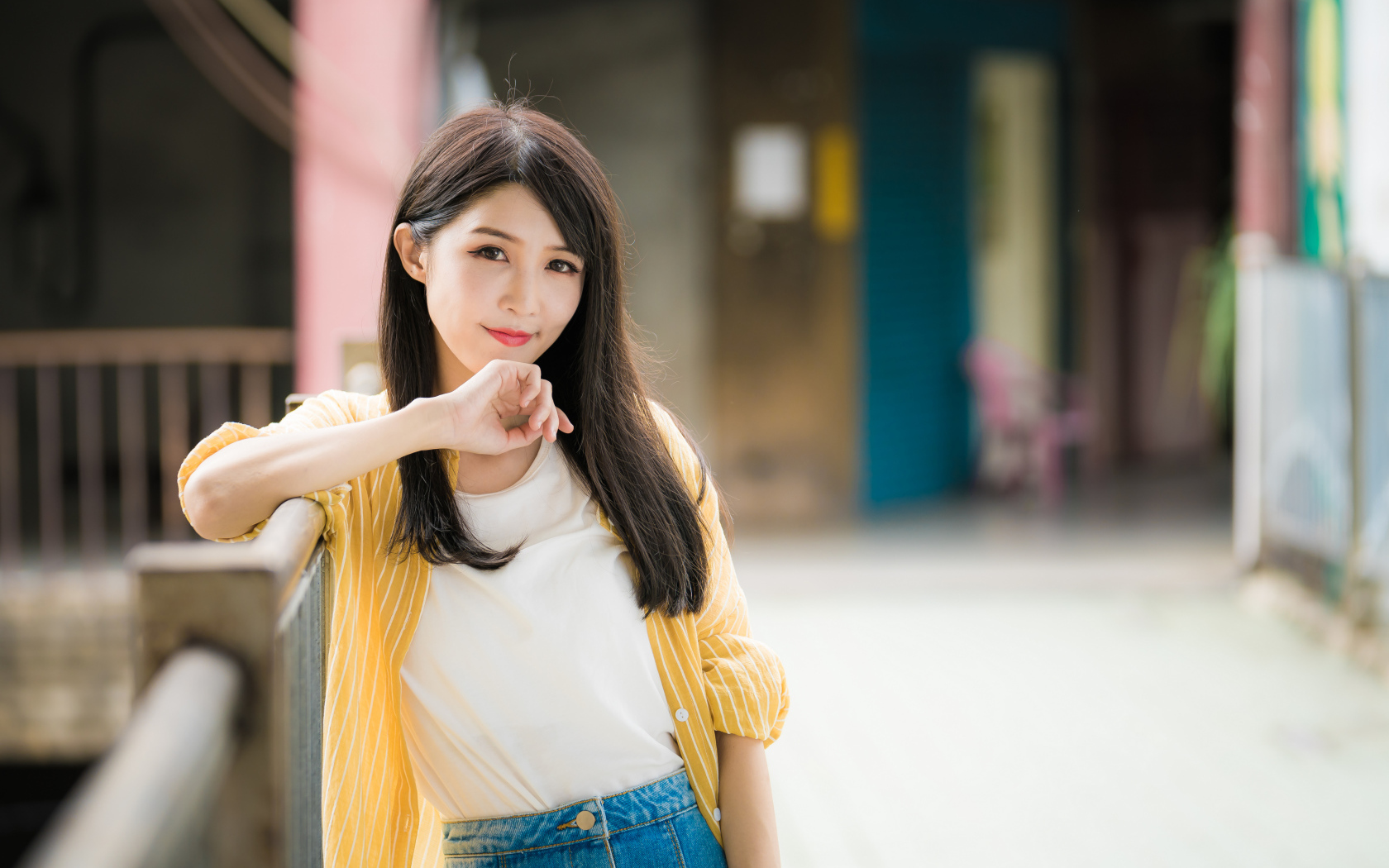 Молодая азиатка в белой майке и полосатой рубашке 