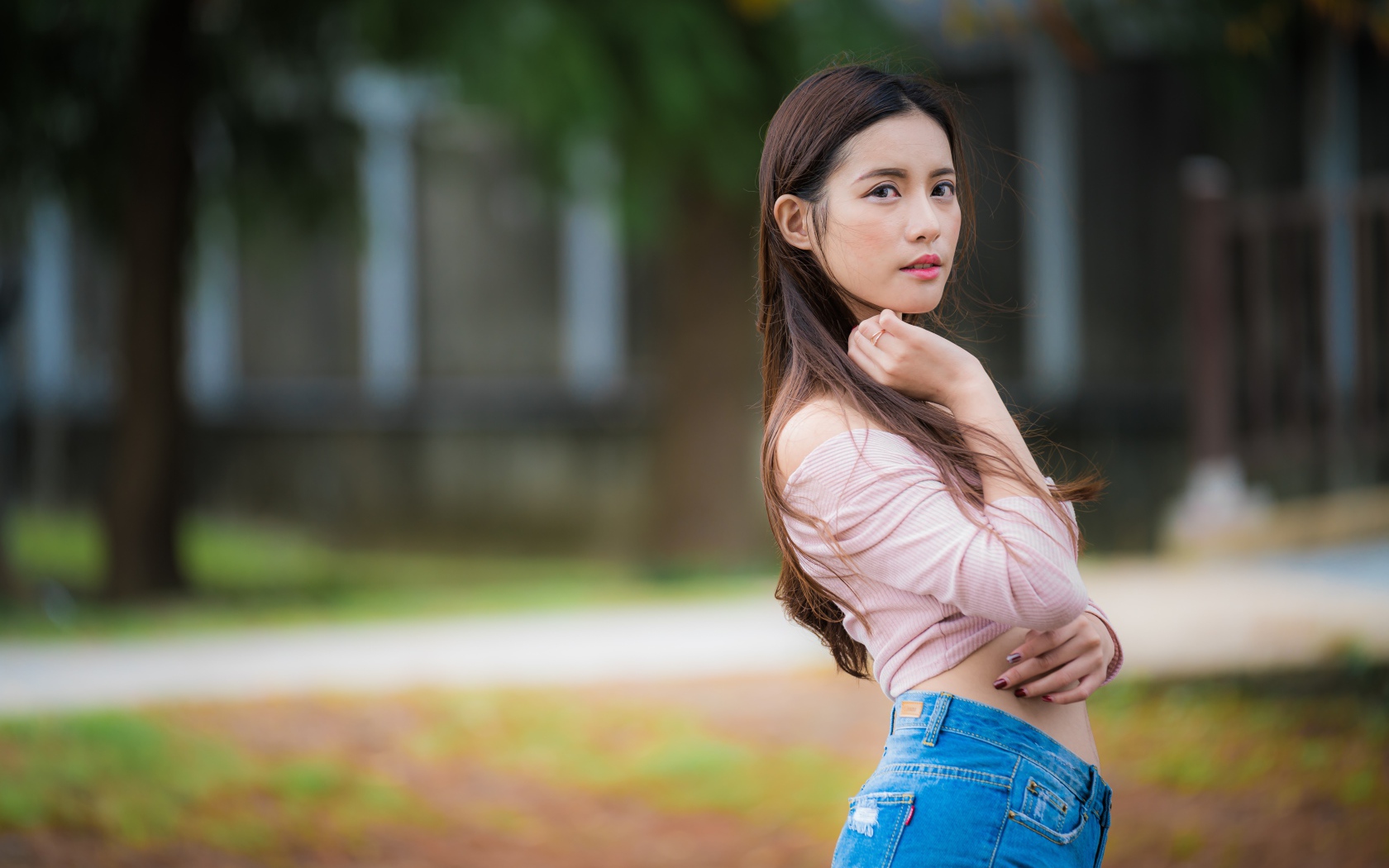 Молодая азиатка с длинными волосами в синих джинсах