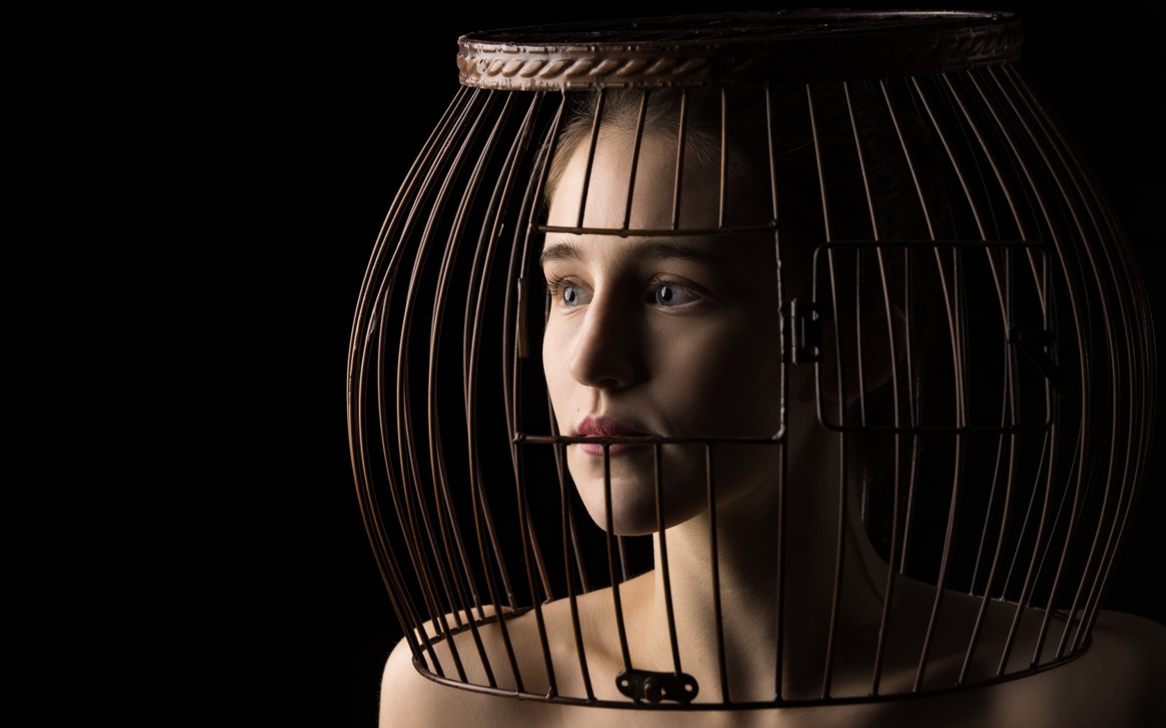 Молодая девушка с клеткой на голове 