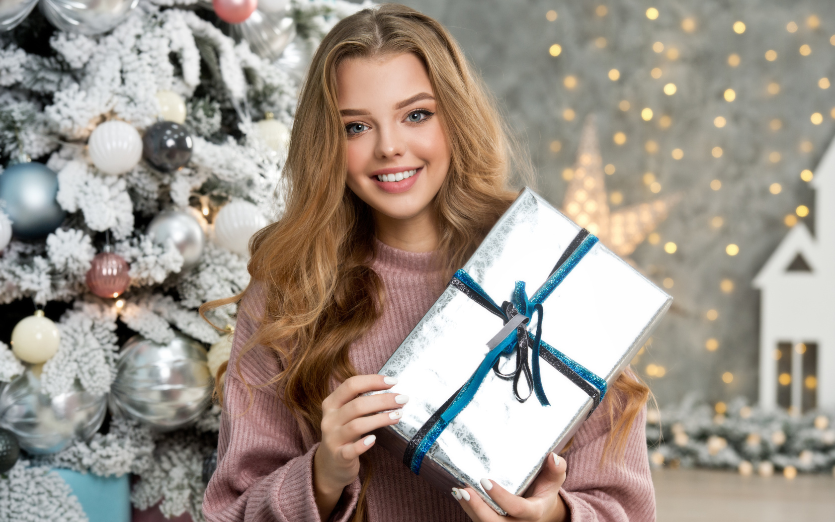 Красивая девушка с подарком у елки на новый год 