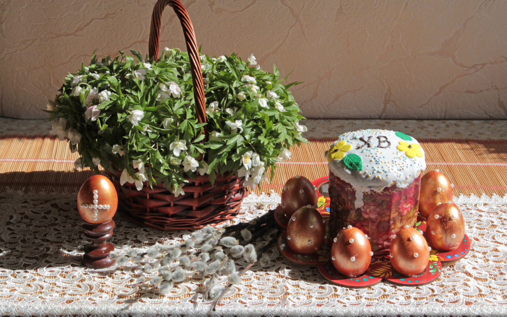 Пасхальный кулич с яйцами на столе с корзинкой цветов на праздник