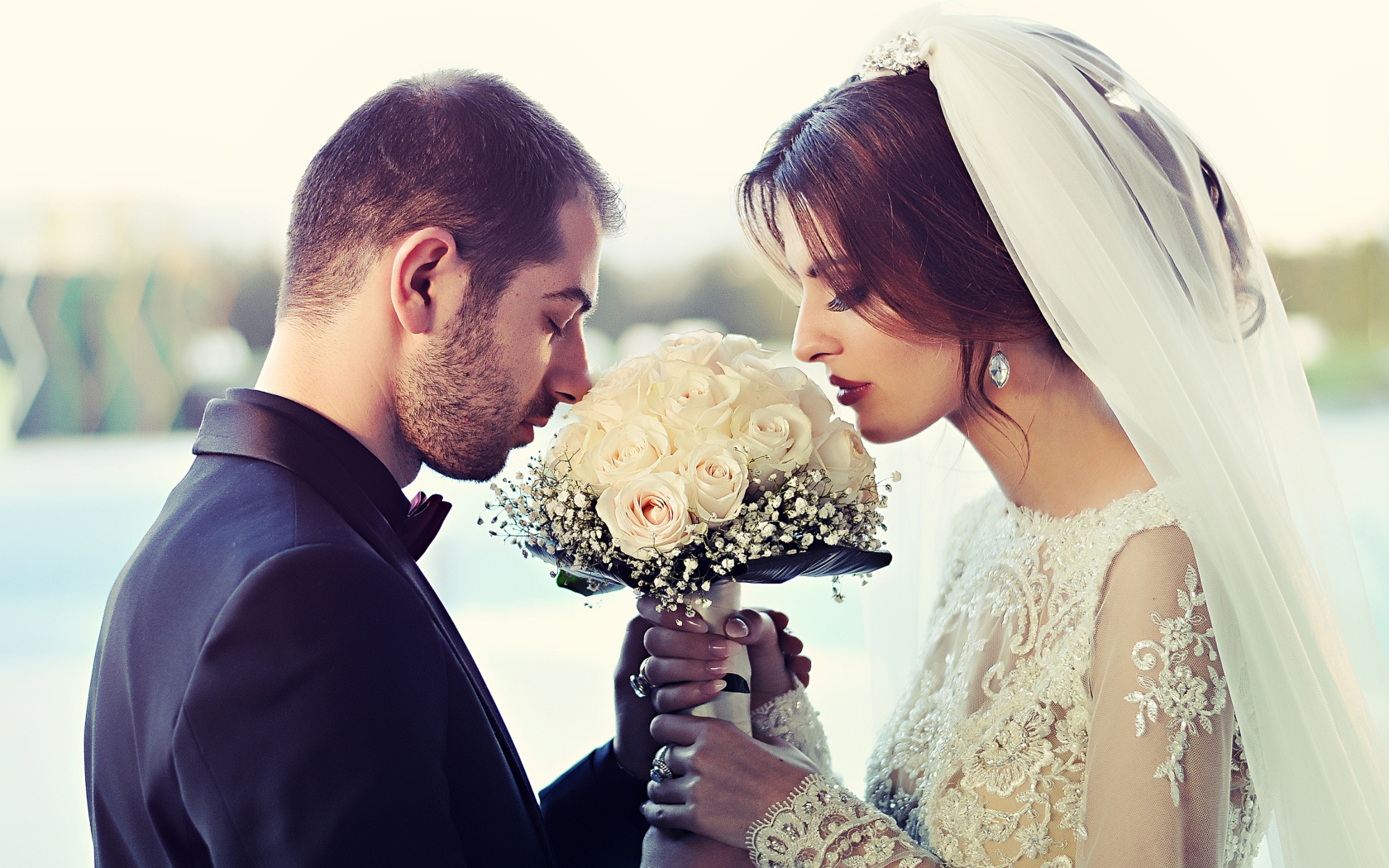 Bride and groom with a bouquet of white roses