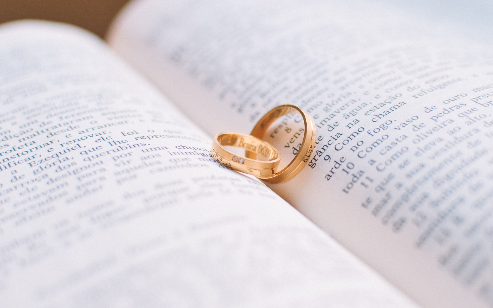Два золотых обручальных кольца лежат на книге 