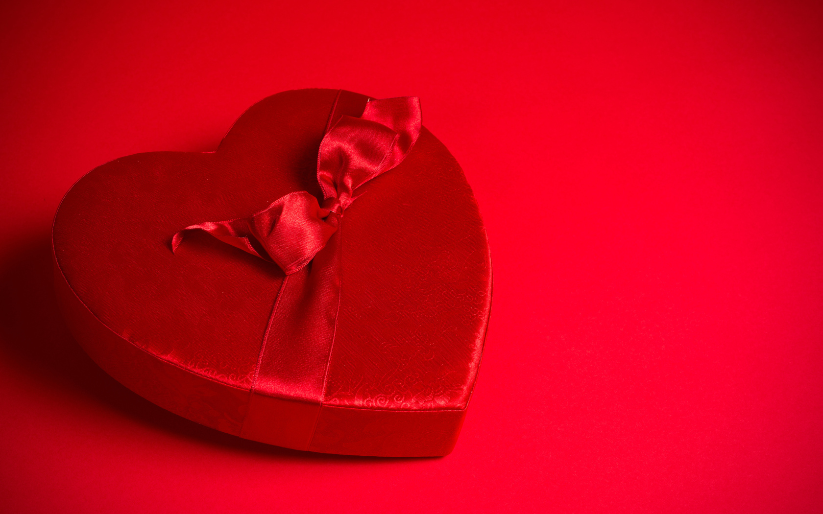 Большое красное сердце с бантом на красном фоне