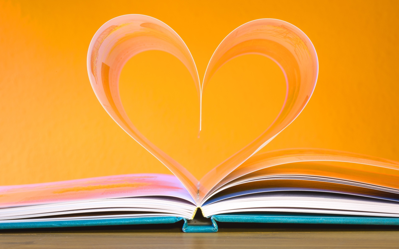 Сердце из страниц книги на желтом фоне