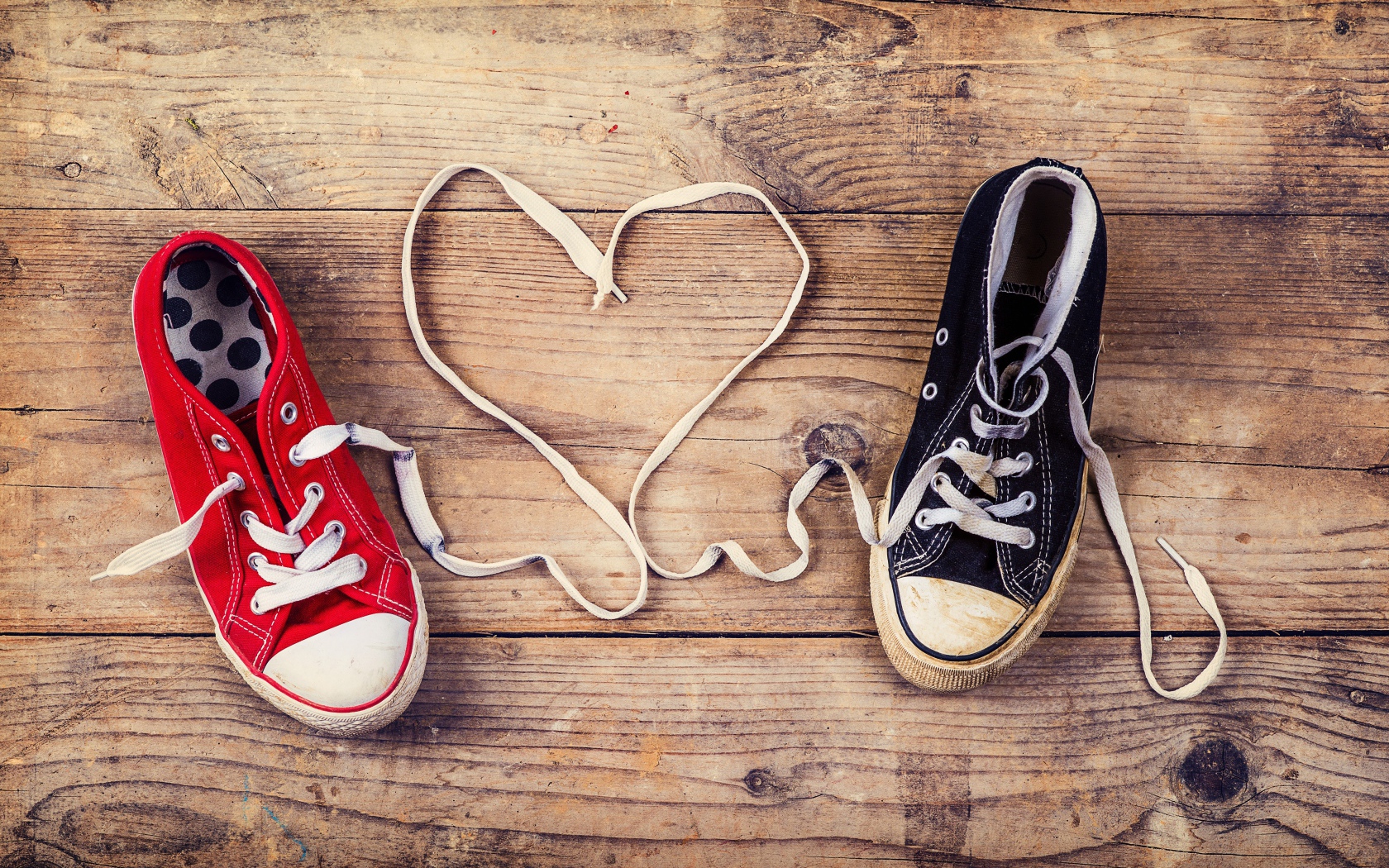 Сердце из шнурков кед на деревянном столе 