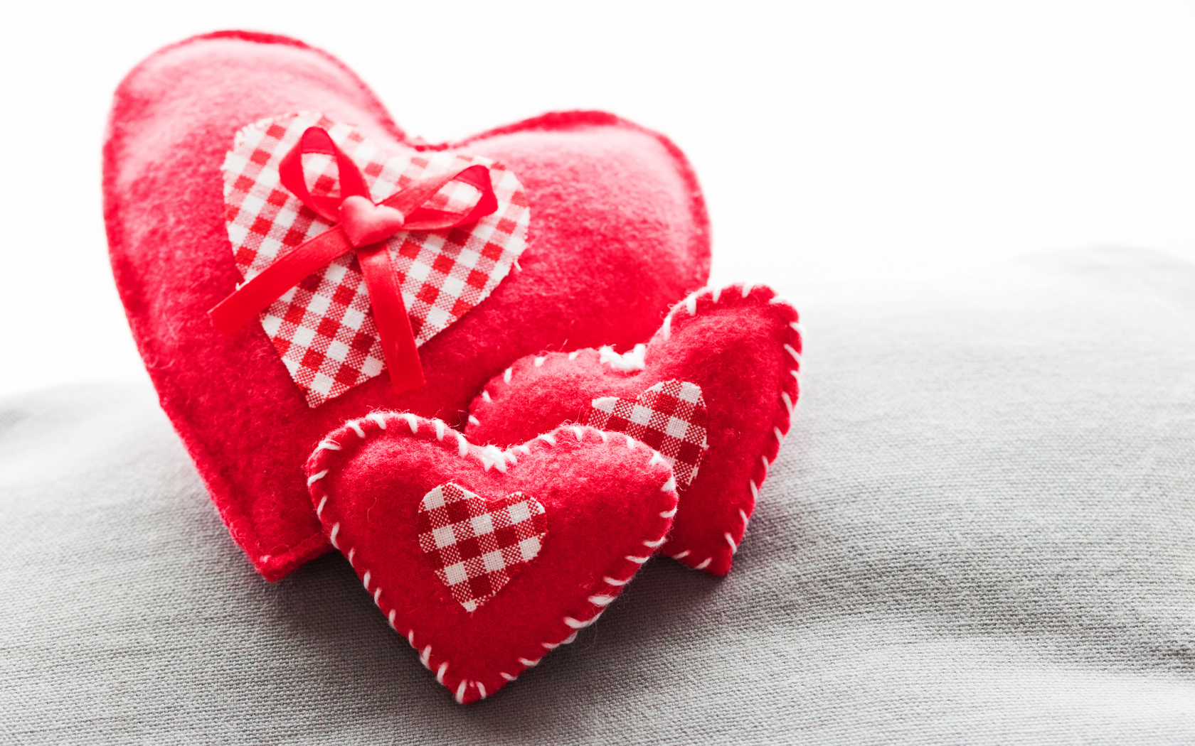 Сердечки из ткани лежат на серой поверхности 