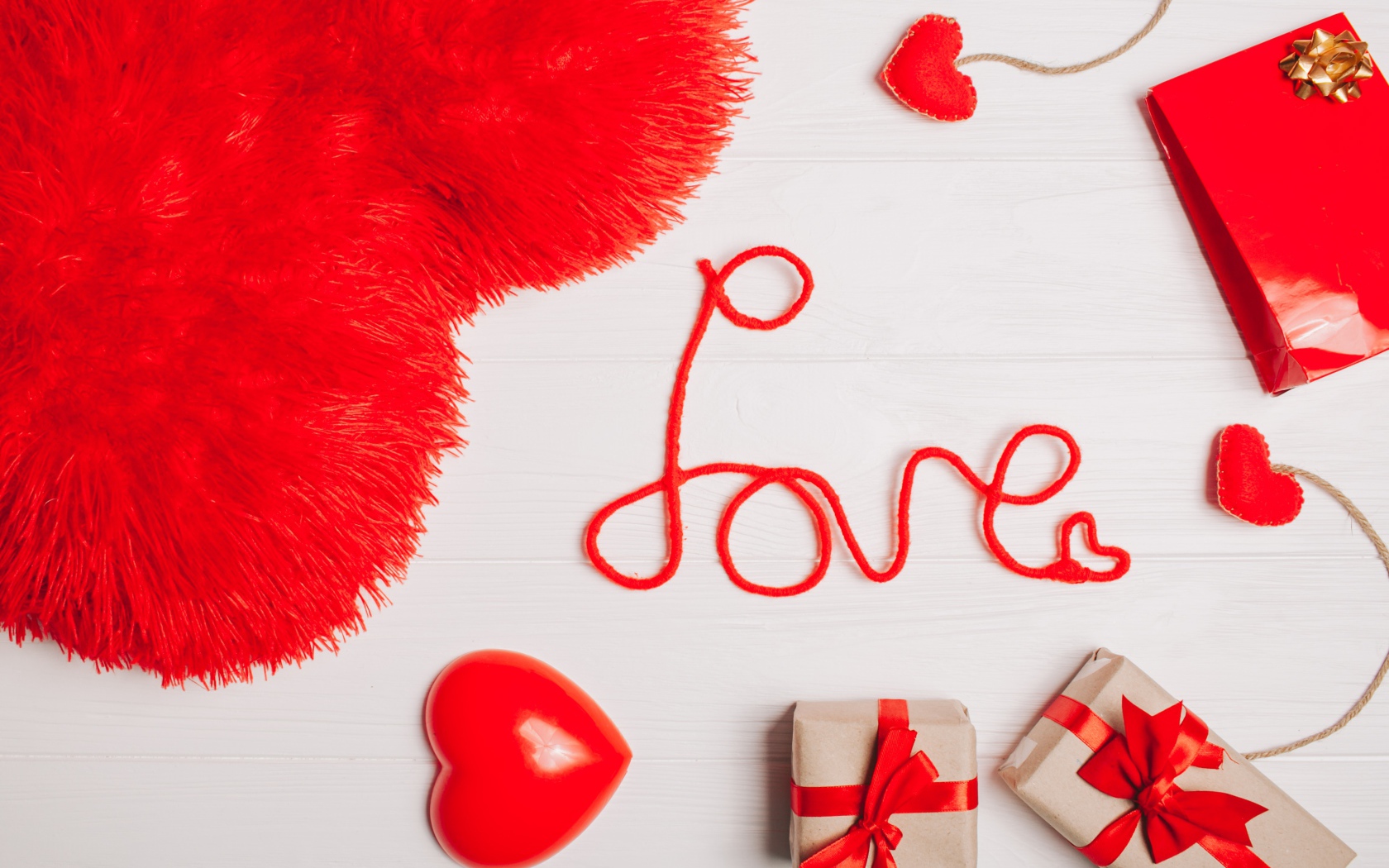 Большая подушка в форме сердца на столе с подарками 