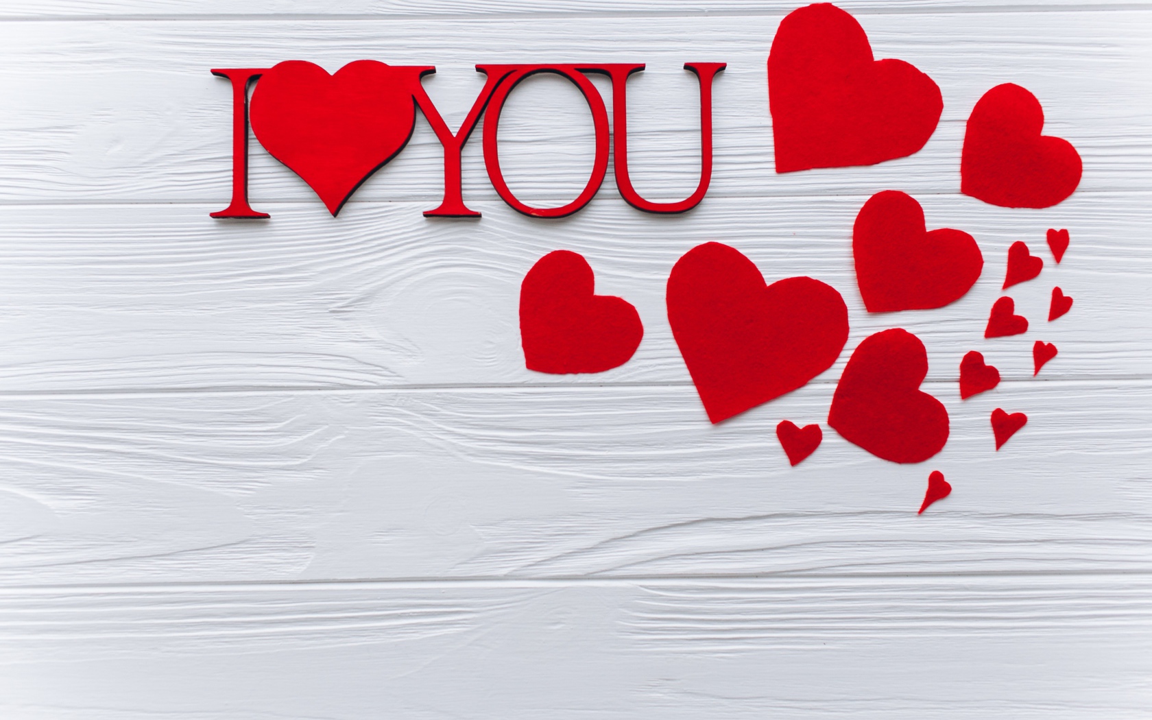 Надпись Я тебя люблю с красными сердечками на столе