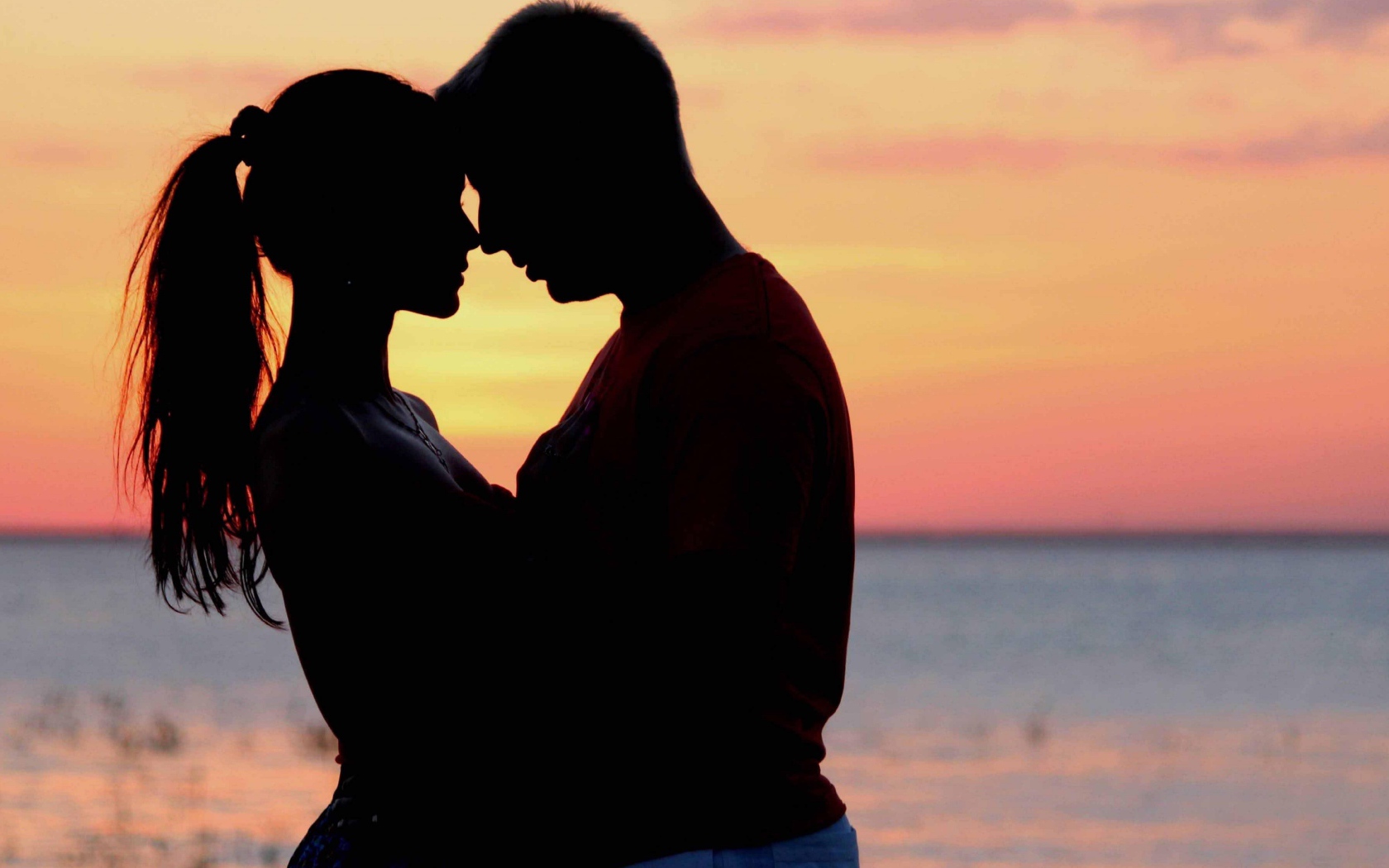 Влюбленная пара на фоне моря в сумерках 