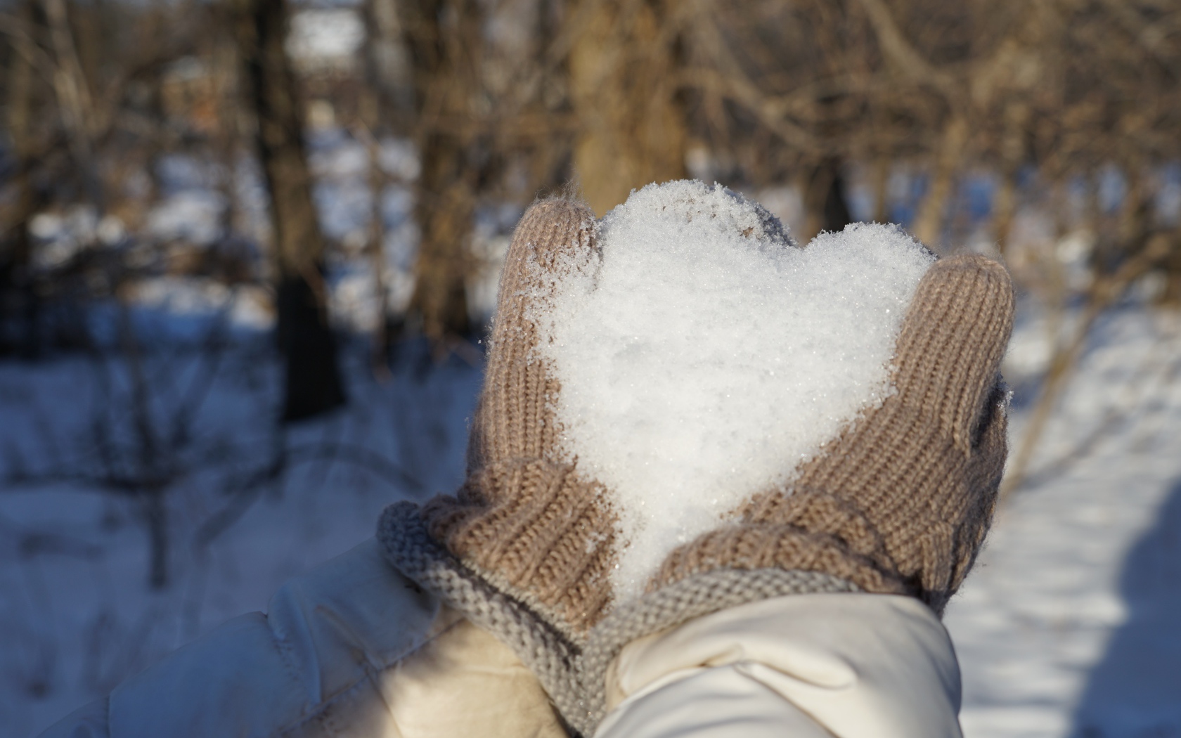 Снег в руках у девушки в перчатках 