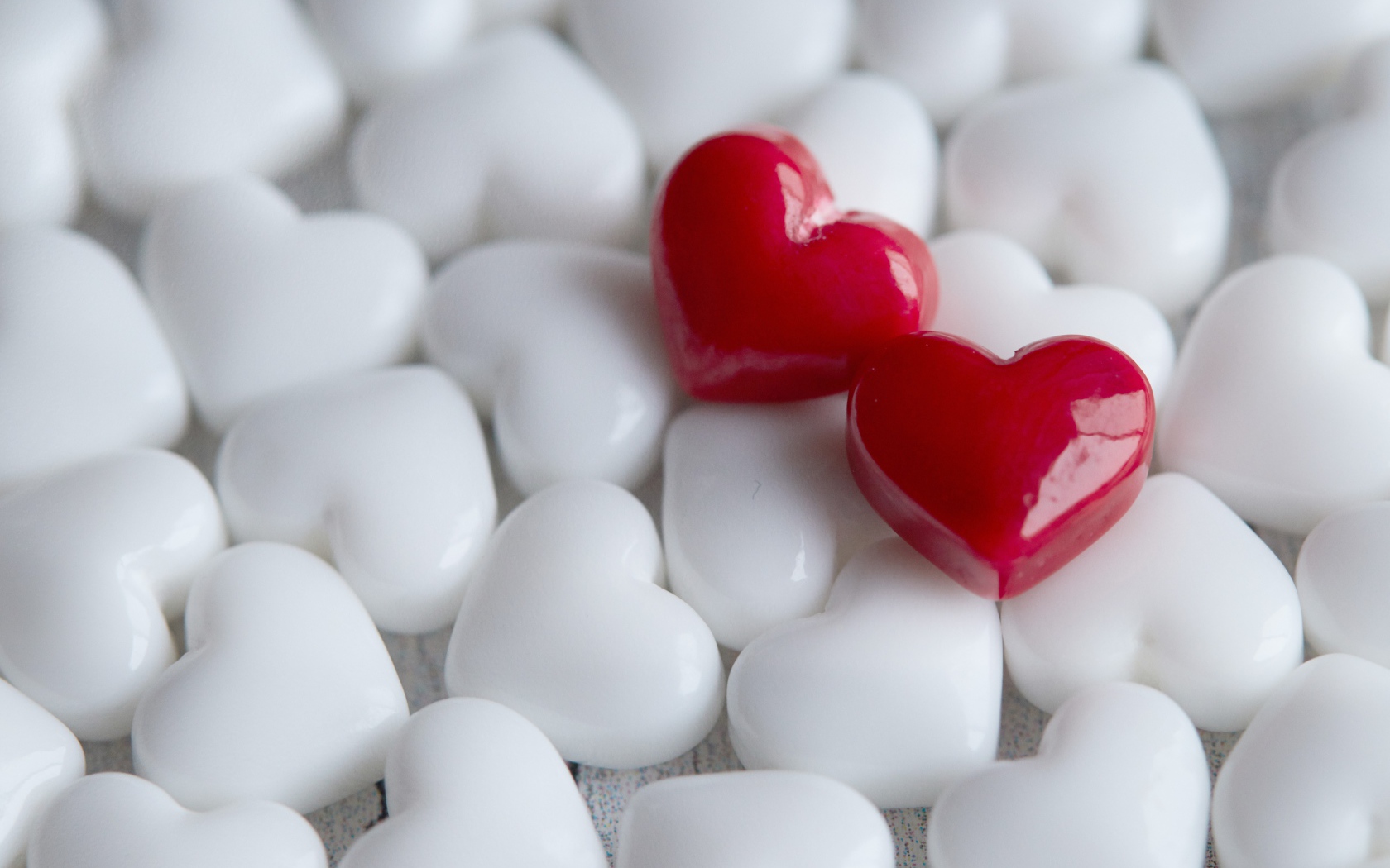 Два красных сердца лежат на белых 