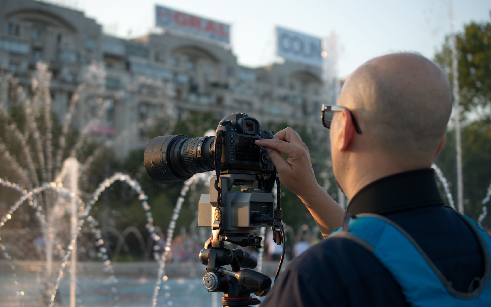 Мужчина снимает на камеру фонтан в парке