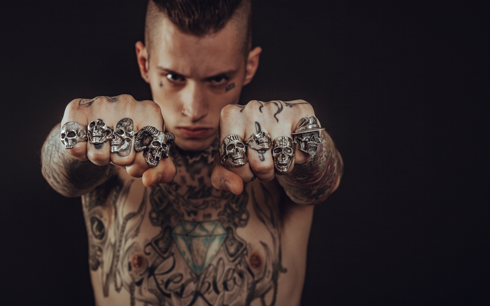 Man with tattoos on his body with rings on his fingers