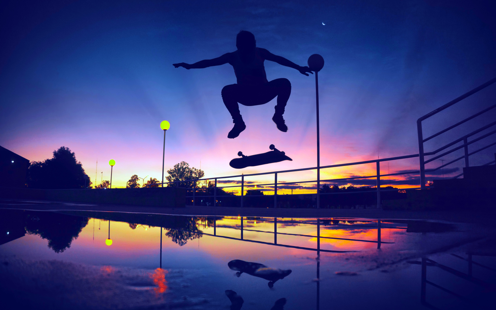 Парень прыгает на скейте на фоне заката